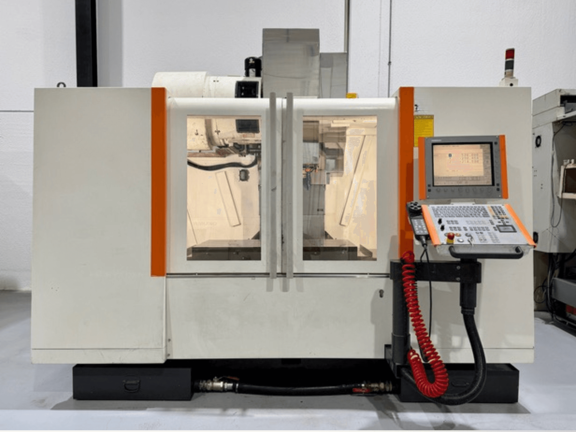 CNC machine met oranje accenten, vooraanzicht. Inclusief bedieningspaneel en zichtbaar binnenwerk.