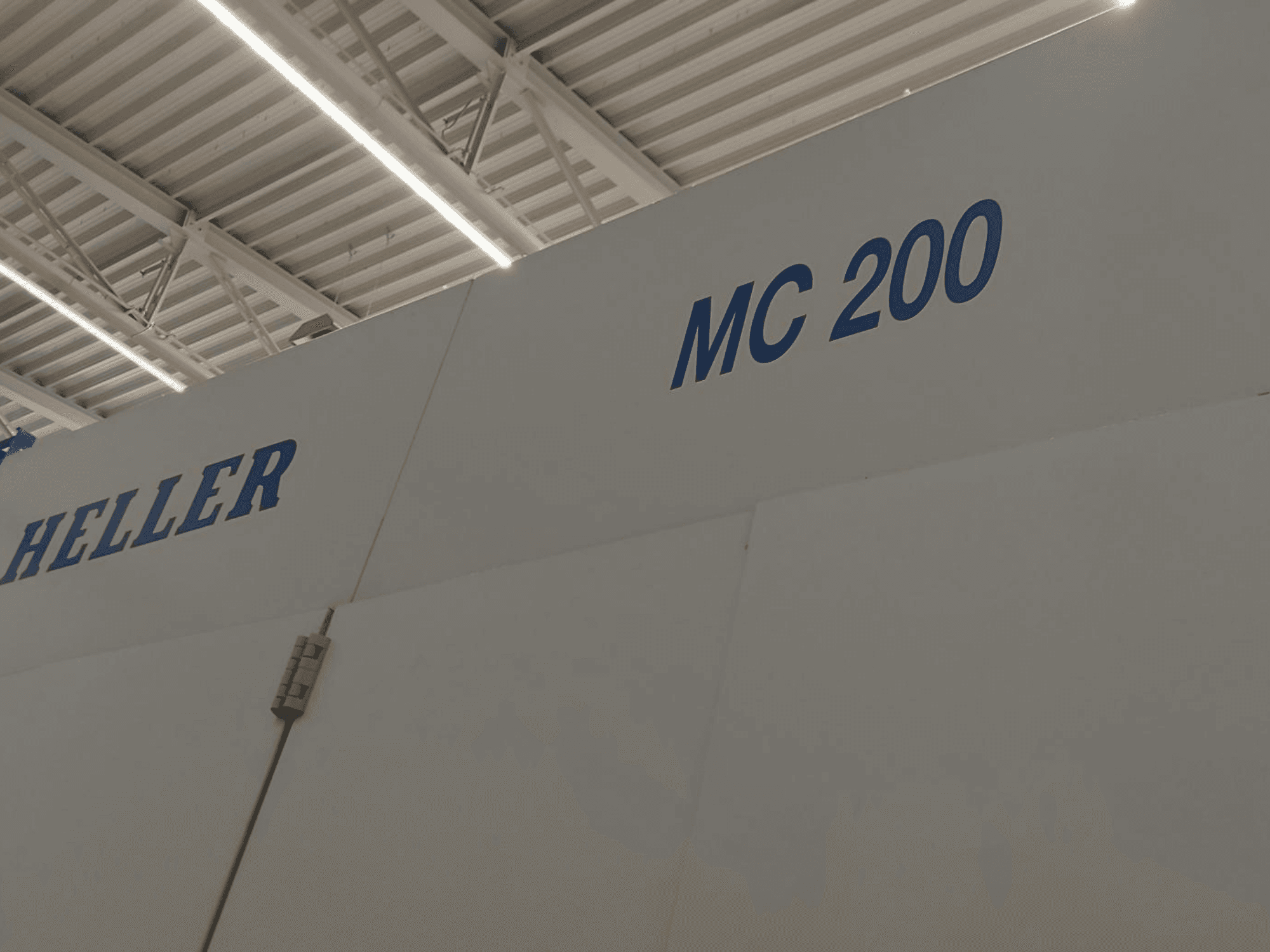 Heller MC 200 horizontaal bewerkingscentrum, van opzij gezien, met merk en model in blauwe letters op een wit oppervlak.