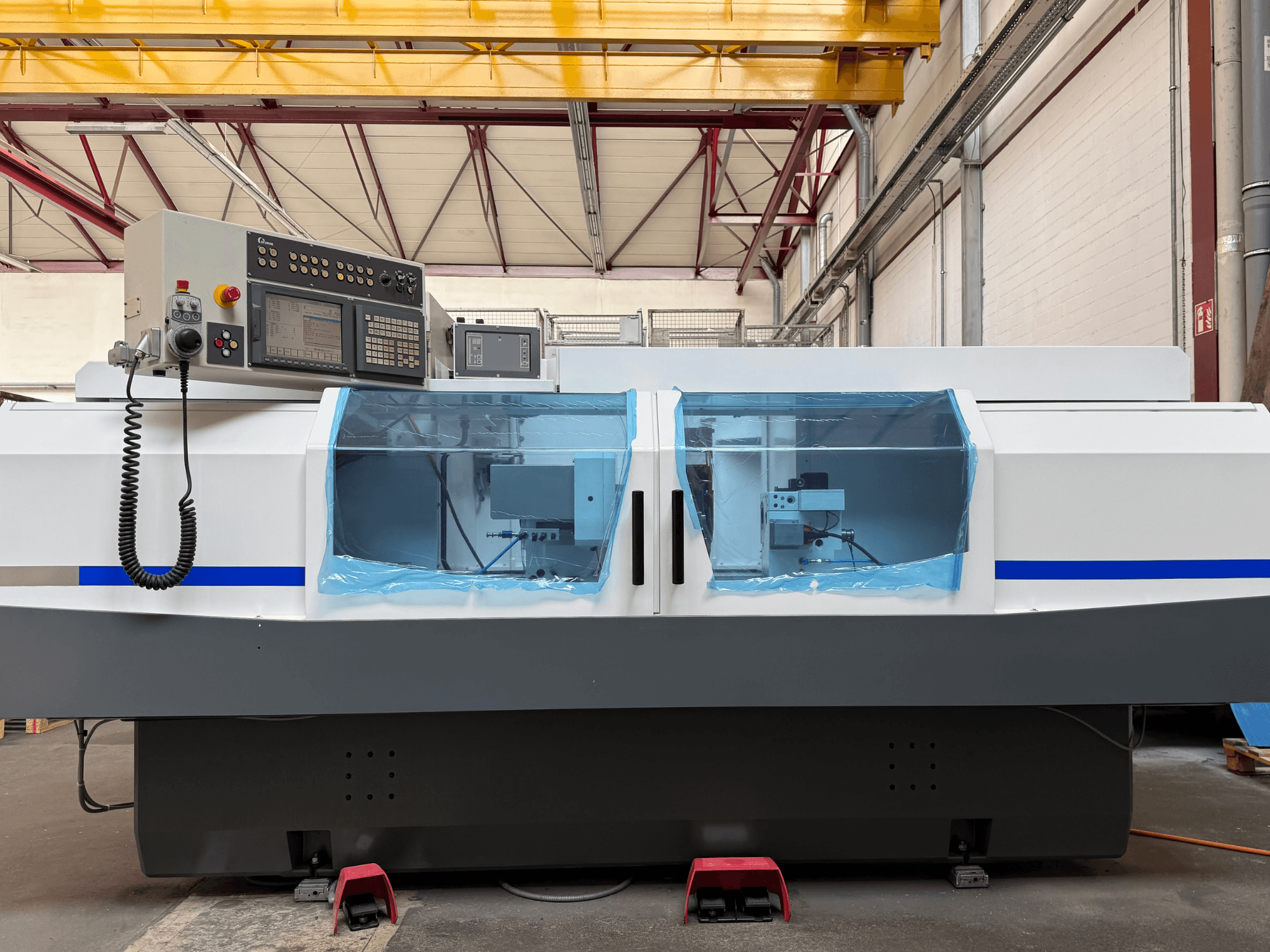 Cilindrische slijpmachine STUDER S33 CNC in zijaanzicht, met bedieningspaneel en doorzichtige veiligheidsafschermingen.