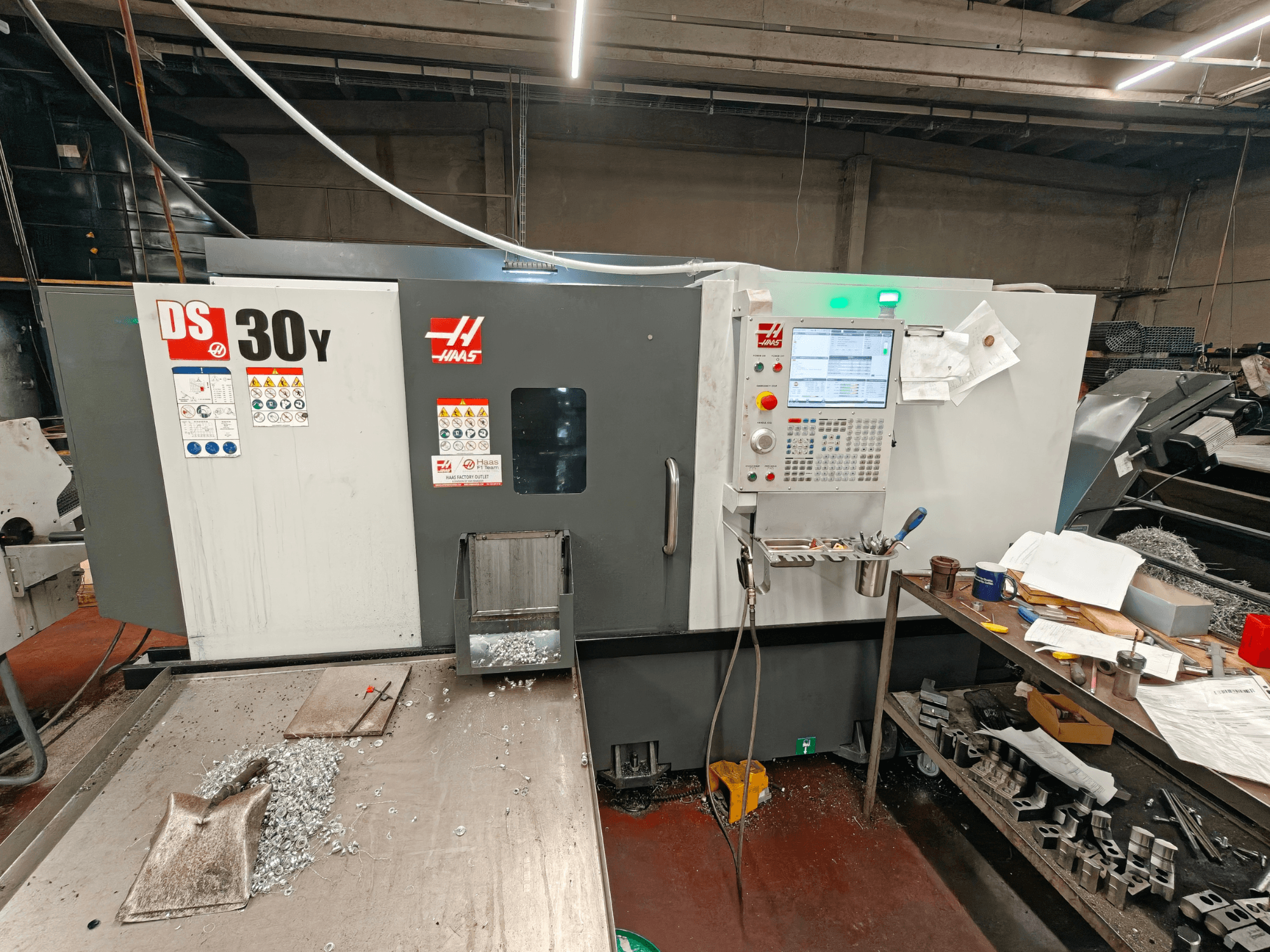 HAAS DS30Y horizontale draaimachine in een werkplaats, vooraanzicht met het bedieningspaneel en metaalkrullen op het werkblad.