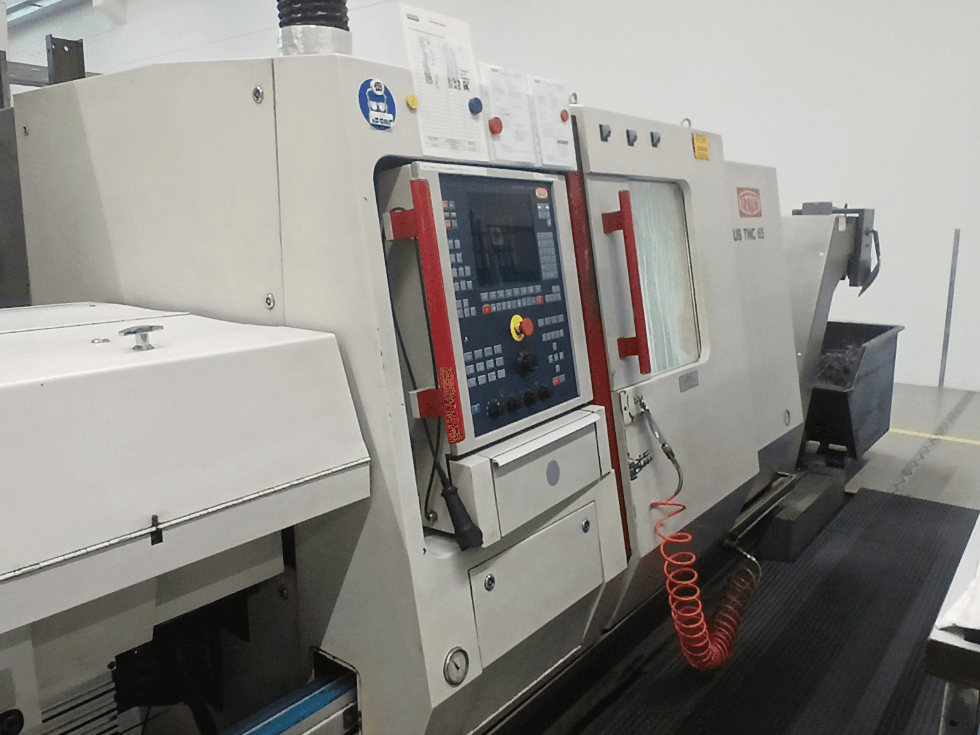 Horizontale draaimachine TRAUB TNC65 DG, vooraanzicht, met bedieningspaneel en gereedschappen, ideaal voor precisiebewerking.