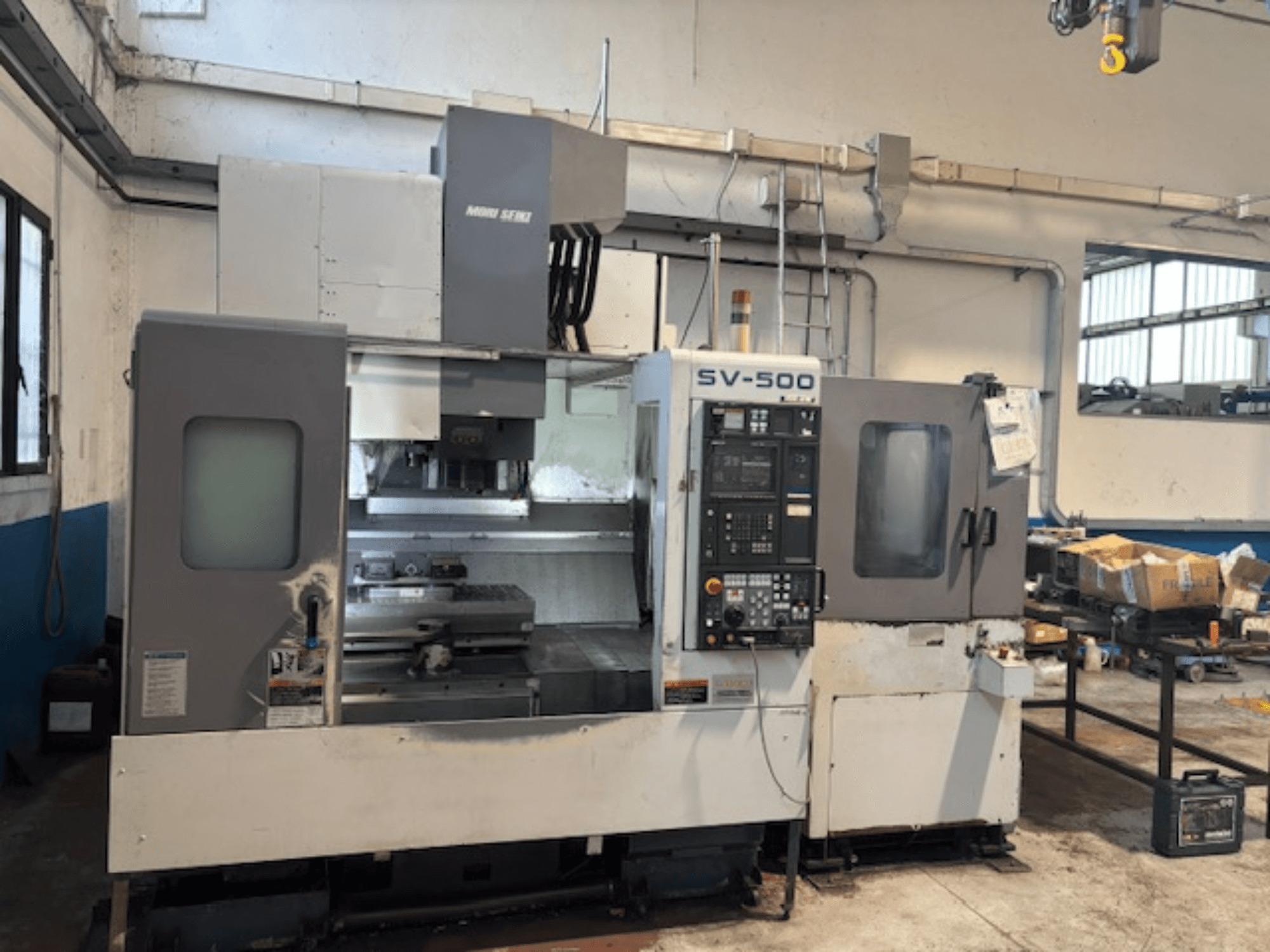 MORI SEIKI SV-500/40 verticaal bewerkingscentrum in een werkplaats, vooraanzicht van het bedieningspaneel en het bewerkingsgebied.
