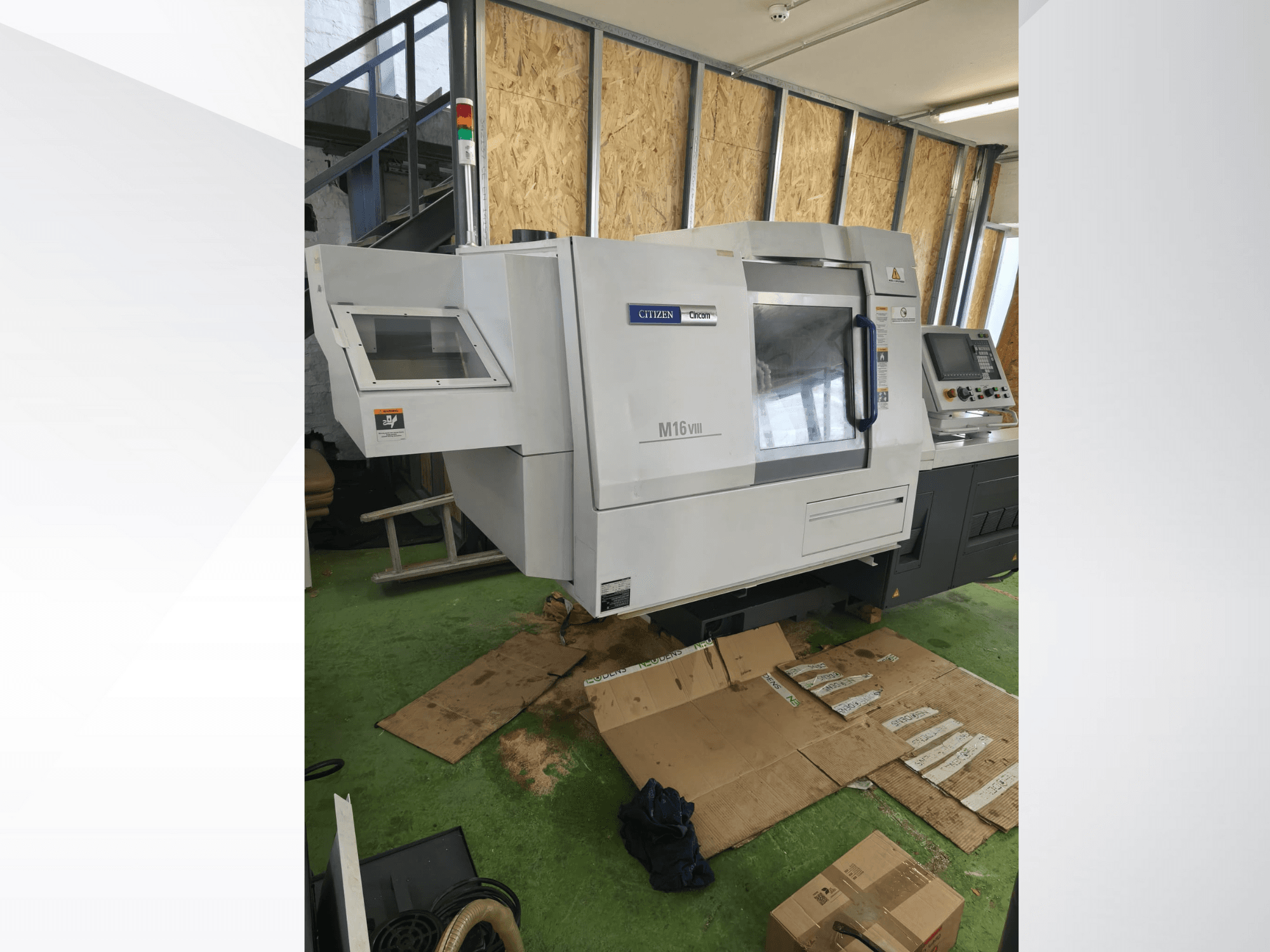 Citizen M16VIII CNC draaibank in vooraanzicht, met bedieningspaneel en waarschuwingslampjes, geplaatst op groene vloer.