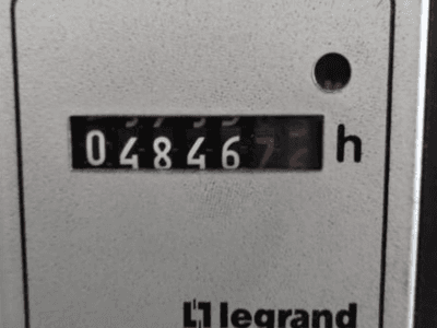 Legrand urenteller met 048467.6, vooraanzicht met rood indicatielampje en zwarte cijfers op een licht getextureerde achtergrond.