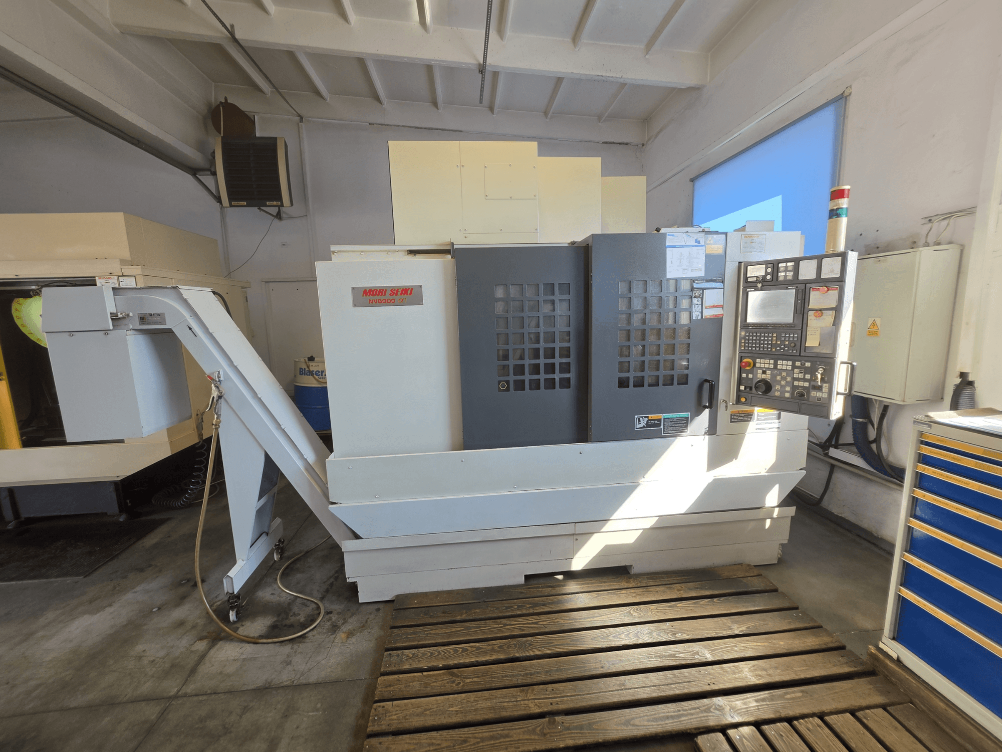 MORI SEIKI NV 5000 alpha1 verticaal bewerkingscentrum, vooraanzicht met bedieningspaneel en machinekenmerken in een werkplaatsomgeving.