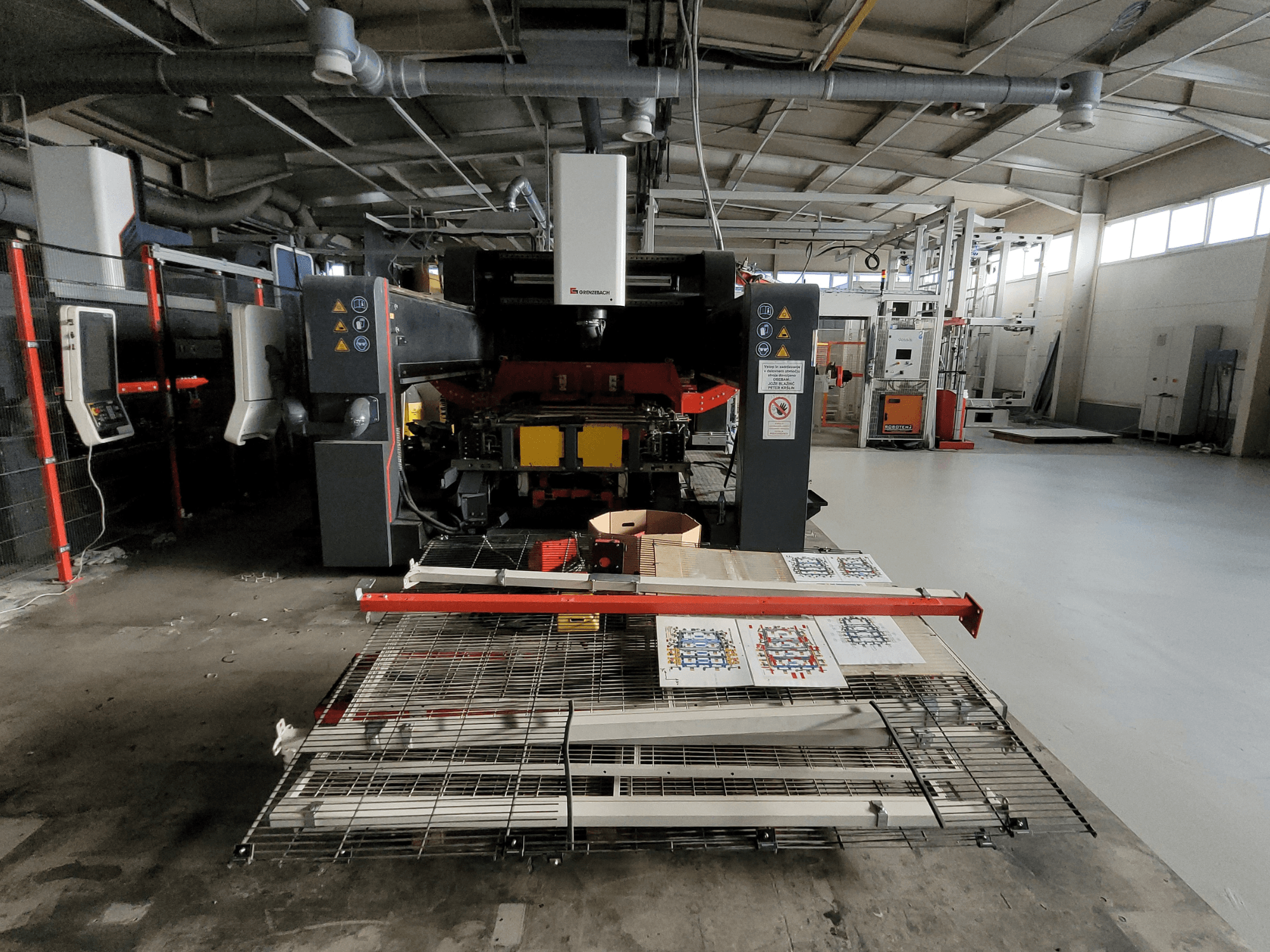 De GRENZEBACH FSW-machine DSM 2400, gezien vanaf de voorkant in fabrieksinstelling, toont de bewerkingsopstelling met bedrukte materialen en apparatuur.