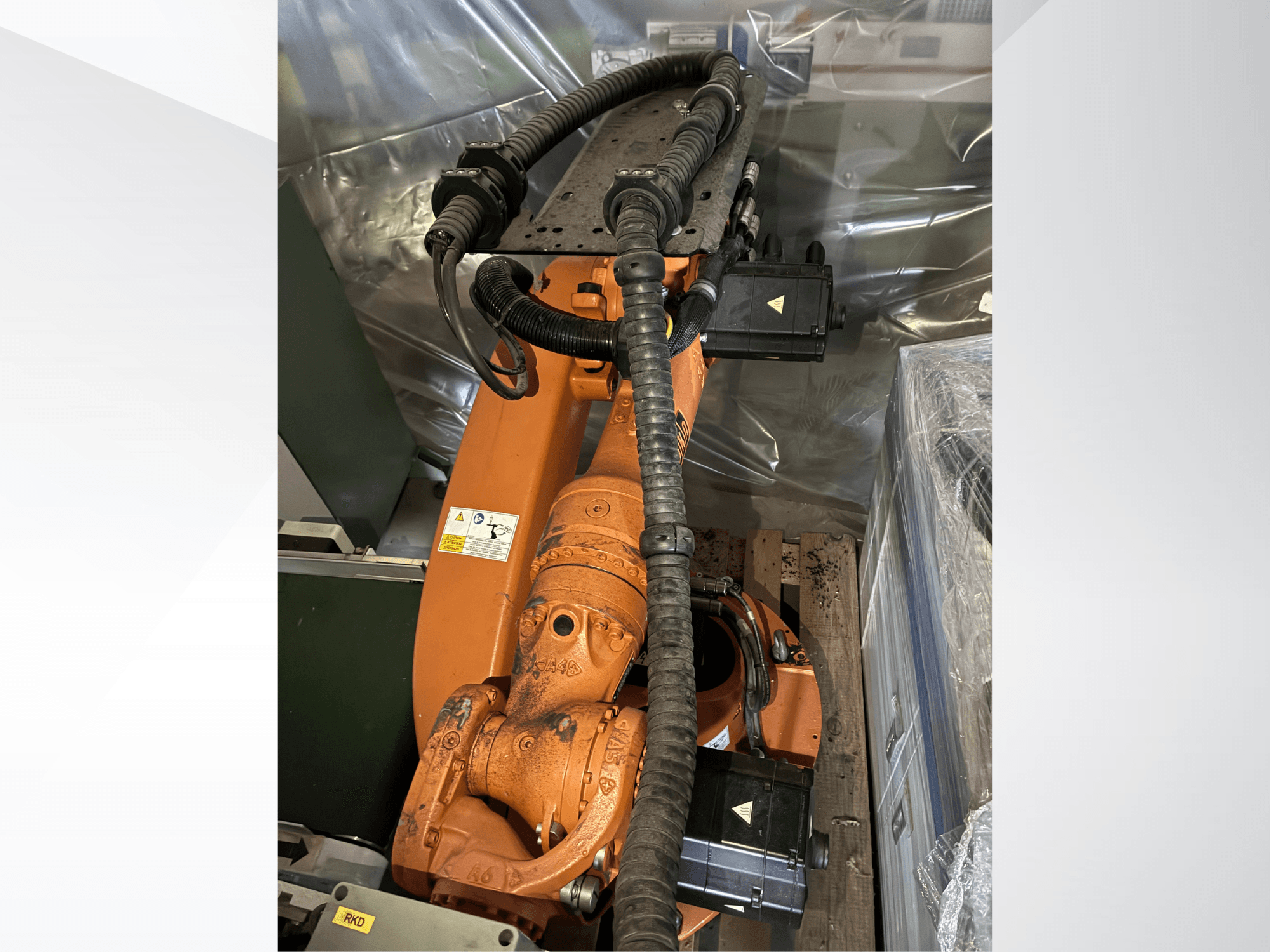 KUKA KR16-2-robotarm in oranje, gezien van bovenaf, met aansluitingen en beschermbuizen.