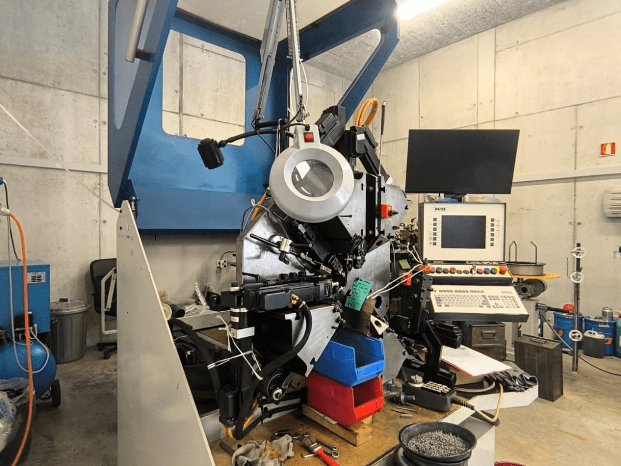 De WAFIOS Fmu1-plaatbewerkingsmachine in vooraanzicht, met de bedieningselementen en onderdelen in beeld, geplaatst in een industriële werkruimte.