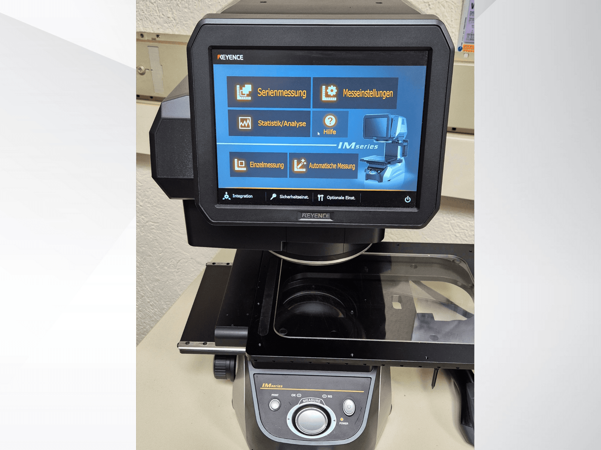 Vooraanzicht van het KEYENCE IM-serie meettoestel met touchscreen display waarop de meetopties en bedieningselementen te zien zijn.