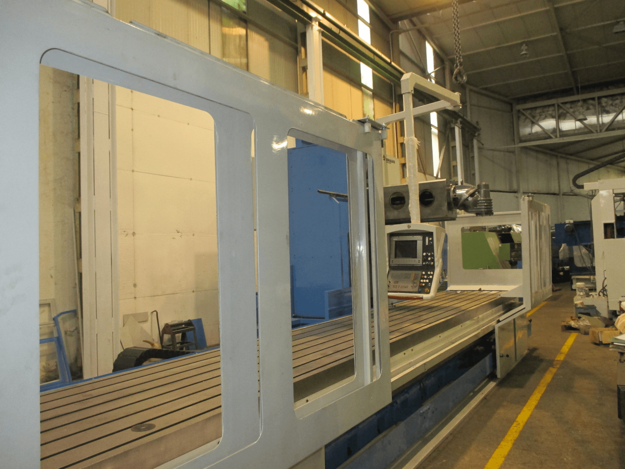 Soraluce SM 8000 freesmachine met bedframe, gezien vanaf de zijkant, met bedieningspaneel en metalen werkblad met groeven.