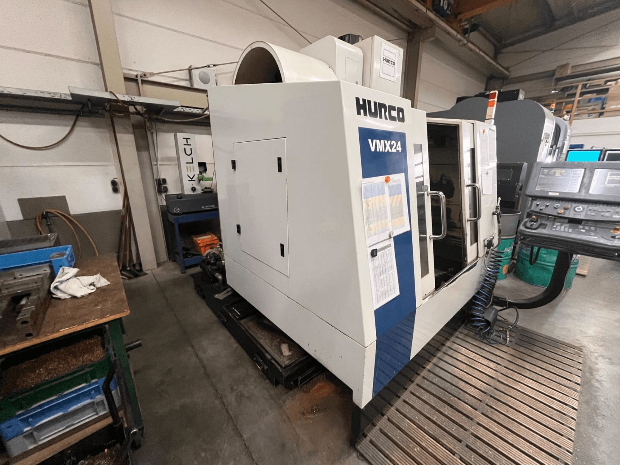 Hurco VMX24 CNC machine in een werkplaats, vooraanzicht; heeft een bedieningspaneel en open toegangsdeur.