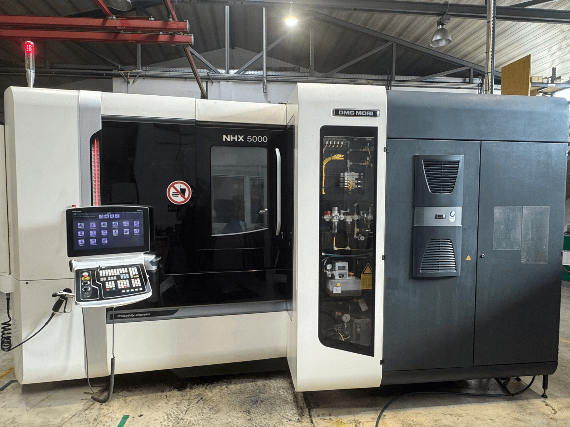 Vooraanzicht van DMG MORI NHX 5000 horizontaal bewerkingscentrum, met het bedieningspaneel en machinedetails.