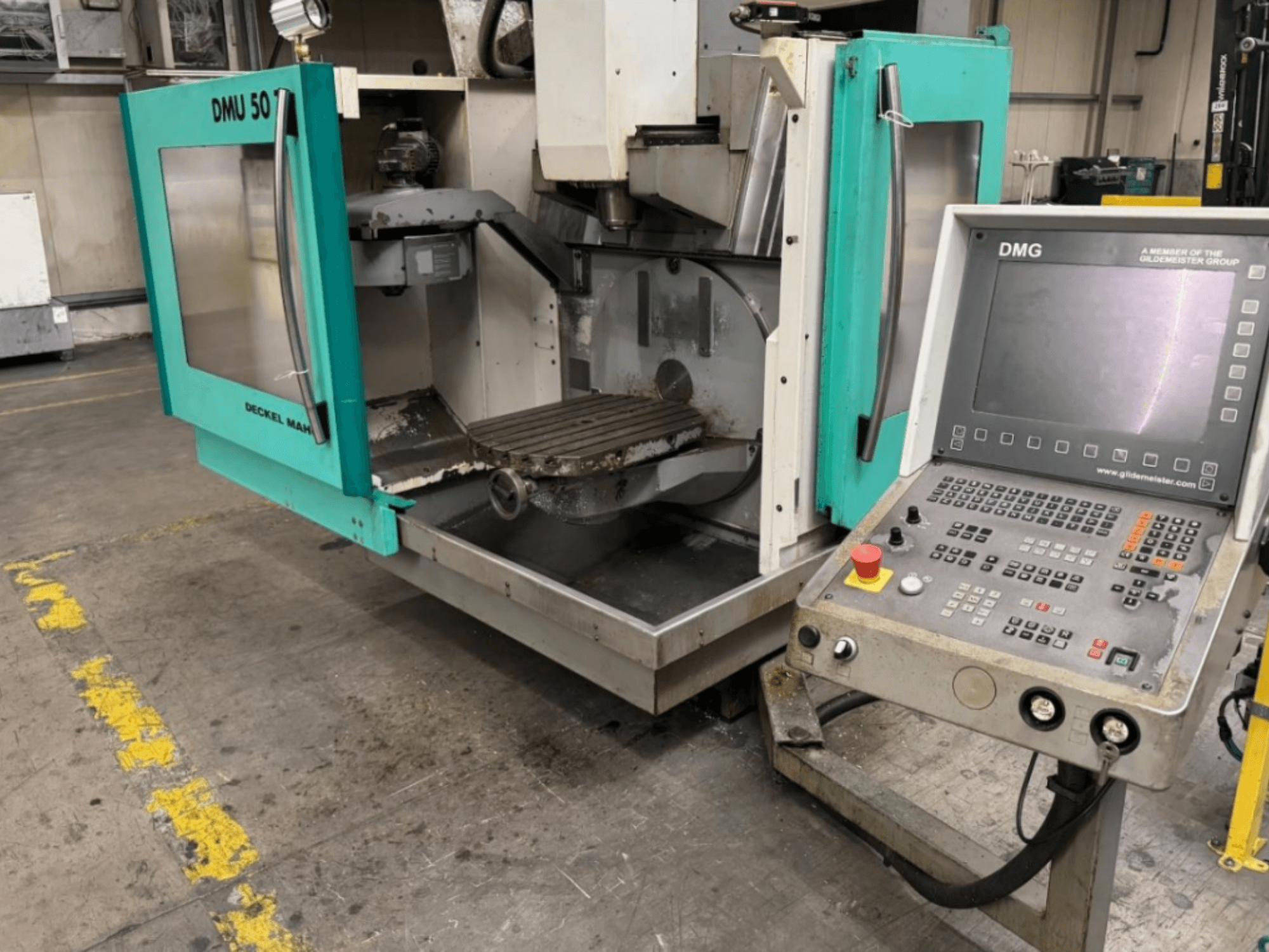 DMG DMU 50 freesmachine met open deuren die het interieur en het bedieningspaneel tonen, gezien vanaf de voorkant.