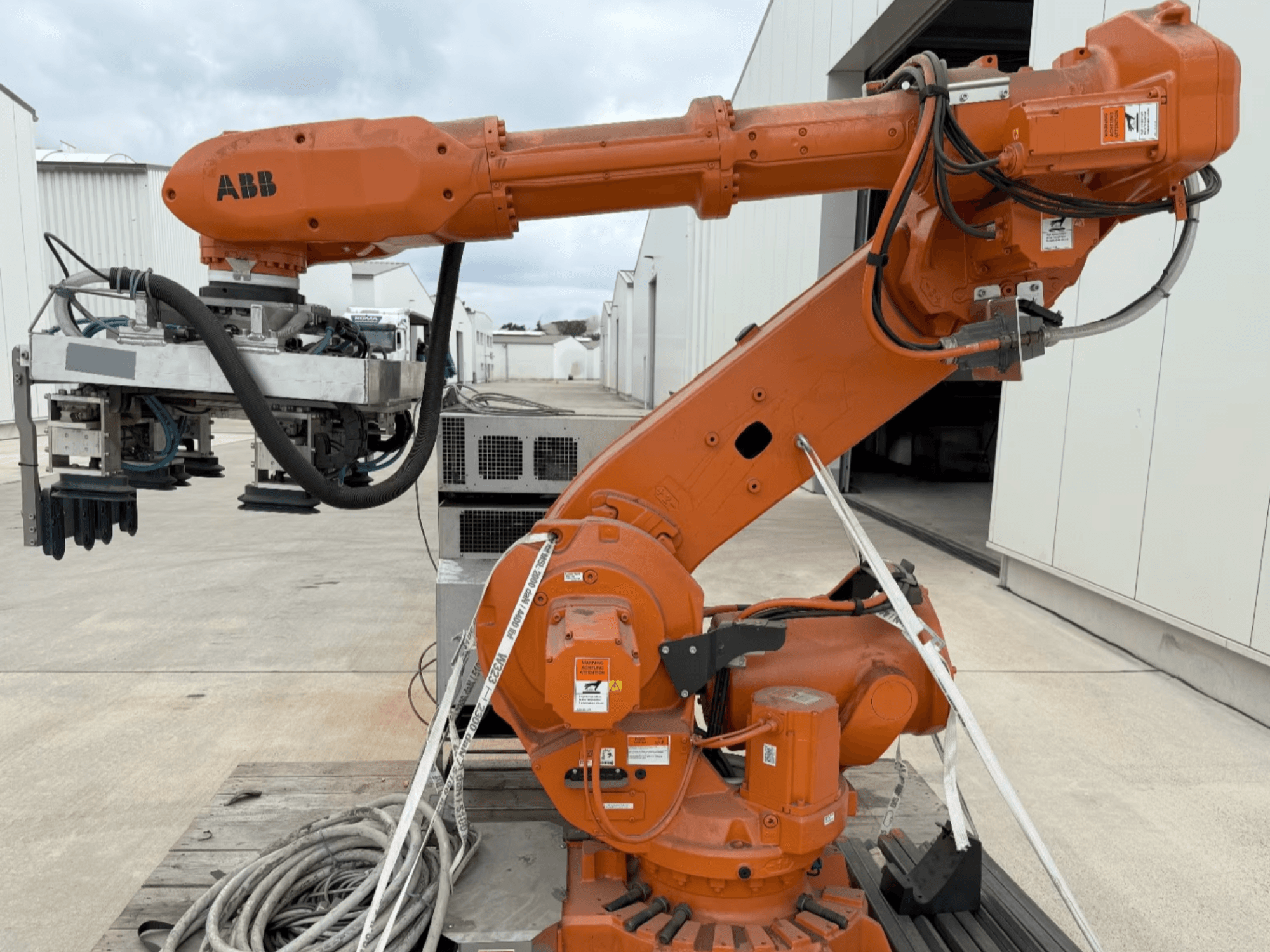 ABB RB 6600-130/3.2 robotarm in zijaanzicht, met een oranje robotarm met grijperaanzetstuk en zichtbare bedrading.