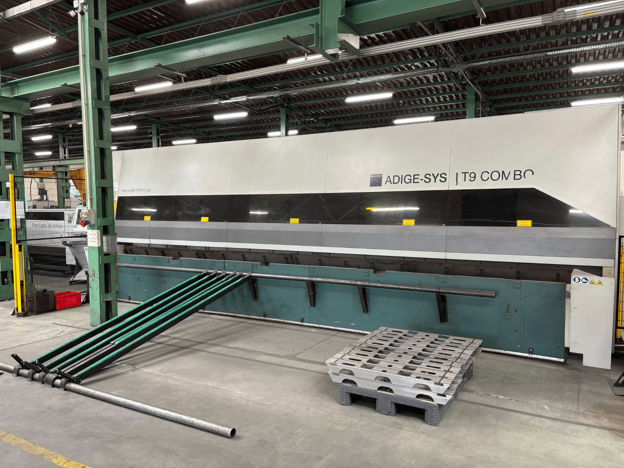 BLM Adige LT9 Combo-buizensnijmachine, vooraanzicht met groene laadarmen en pallet op de fabrieksvloer.
