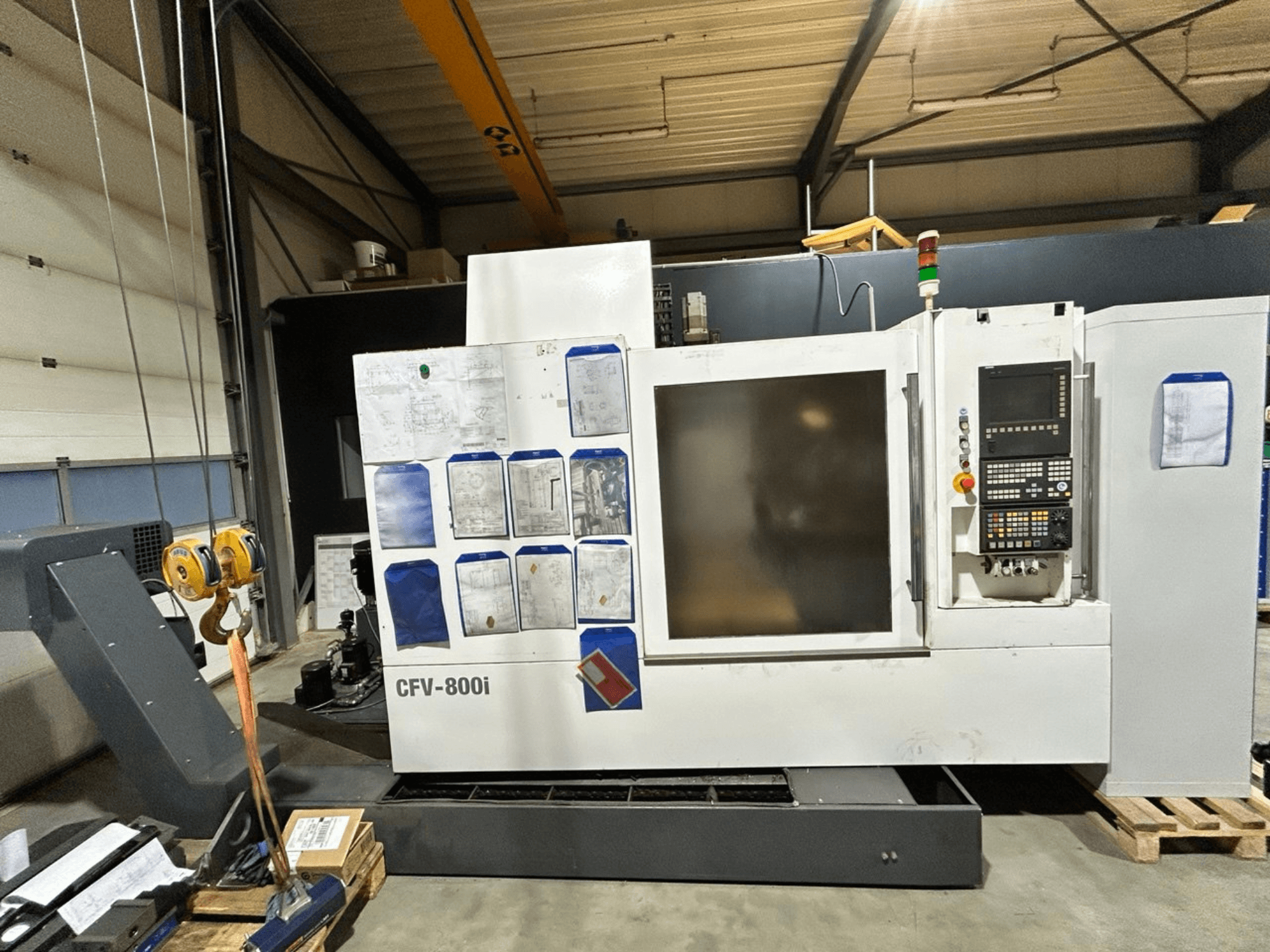 CFV-800i CNC machine in vooraanzicht, met bedieningspaneel, documenten aan de zijkant en rolbrug in fabrieksopstelling.