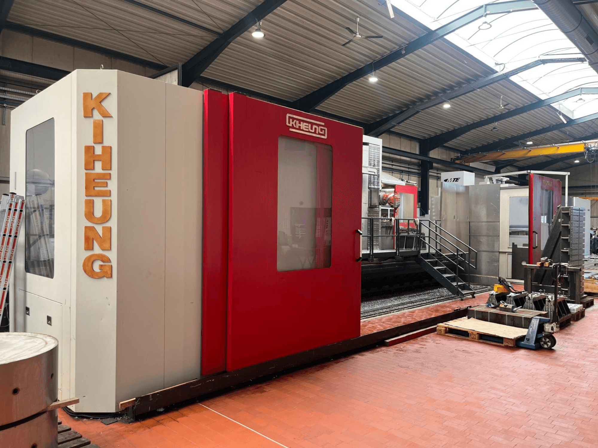 KIHEUNG RIGITRAX X 8000 freesmachine met bedframe in een werkplaats, gezien vanaf de voorkant met een rood-witte behuizing.