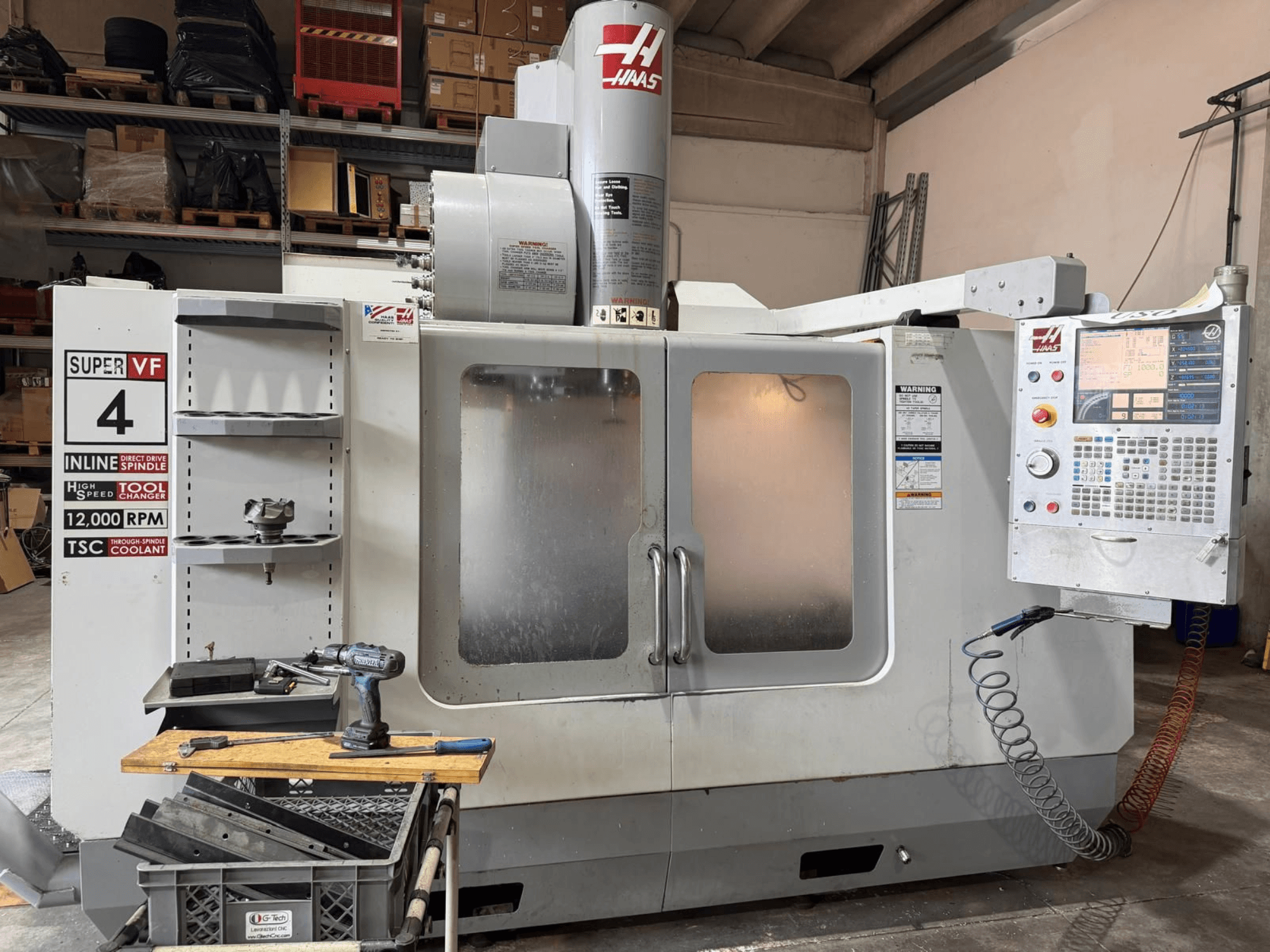 Vooraanzicht van het verticale bewerkingscentrum HAAS VF-4SSHE met bedieningspaneel, gereedschapsrek en een spil met 12.000 tpm; een snelle, nauwkeurige machine.
