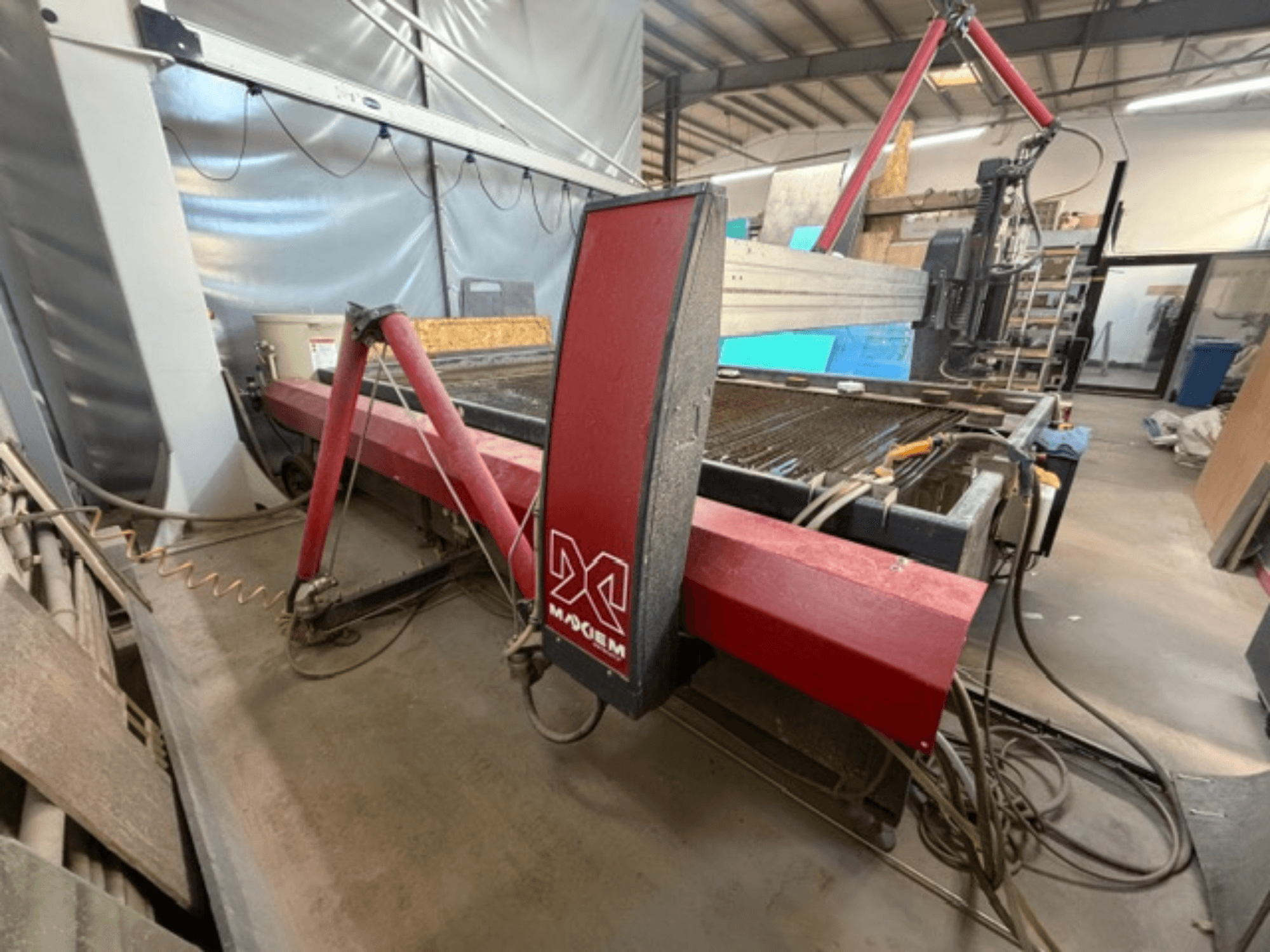 Rode waterstraalsnijmachine van het merk X, gezien vanaf de zijkant, met mechanische onderdelen en leidingdetails.