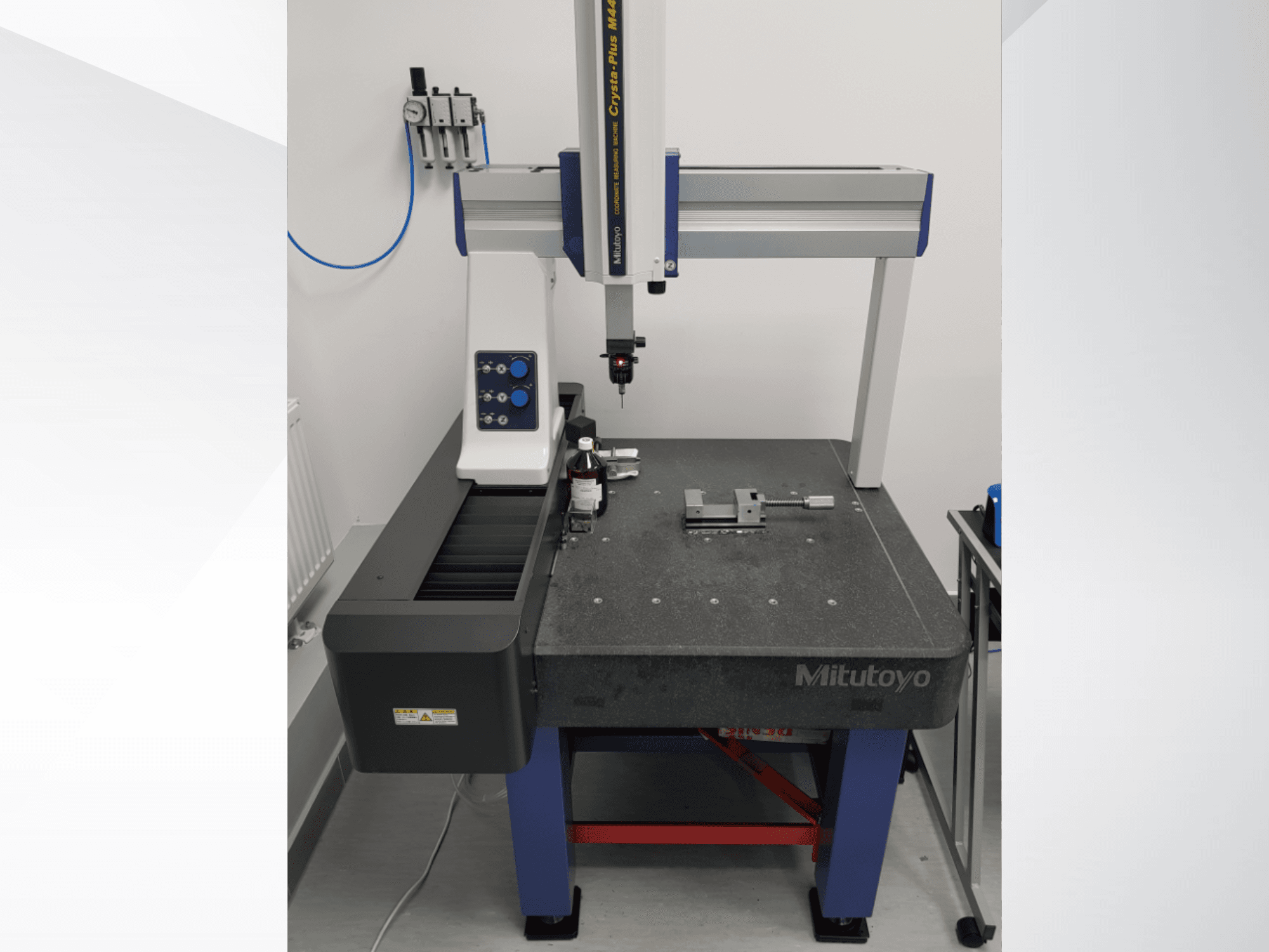 Mitutoyo Crysta-Plus M443 CMM in vooraanzicht, met meetsonde, bedieningspaneel en inspectietafel met opspanningen.
