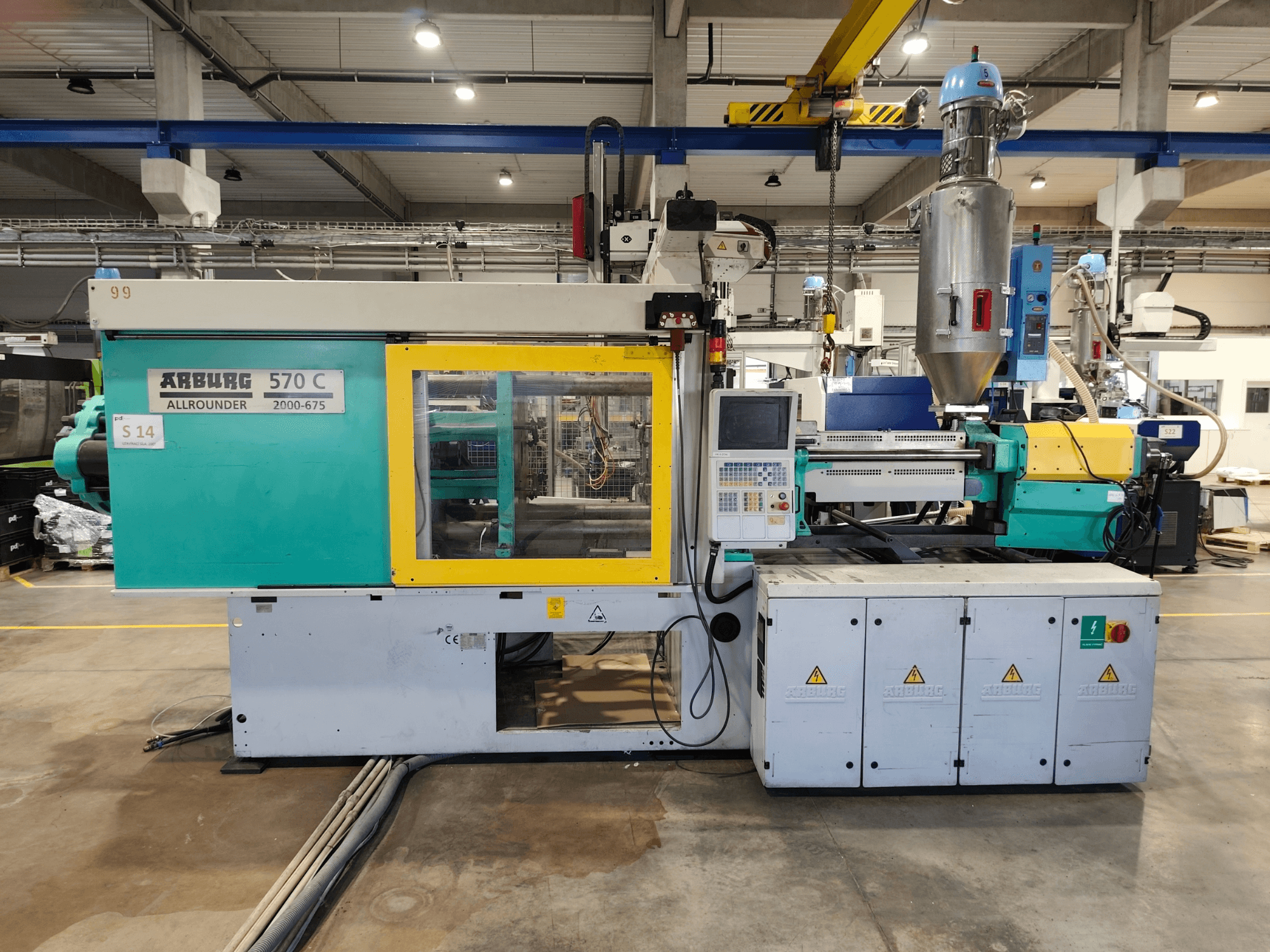 Hydraulische spuitgietmachine Arburg Allrounder 570 C 2000-675, vooraanzicht, met bedieningspaneel en grondstoftrechter.