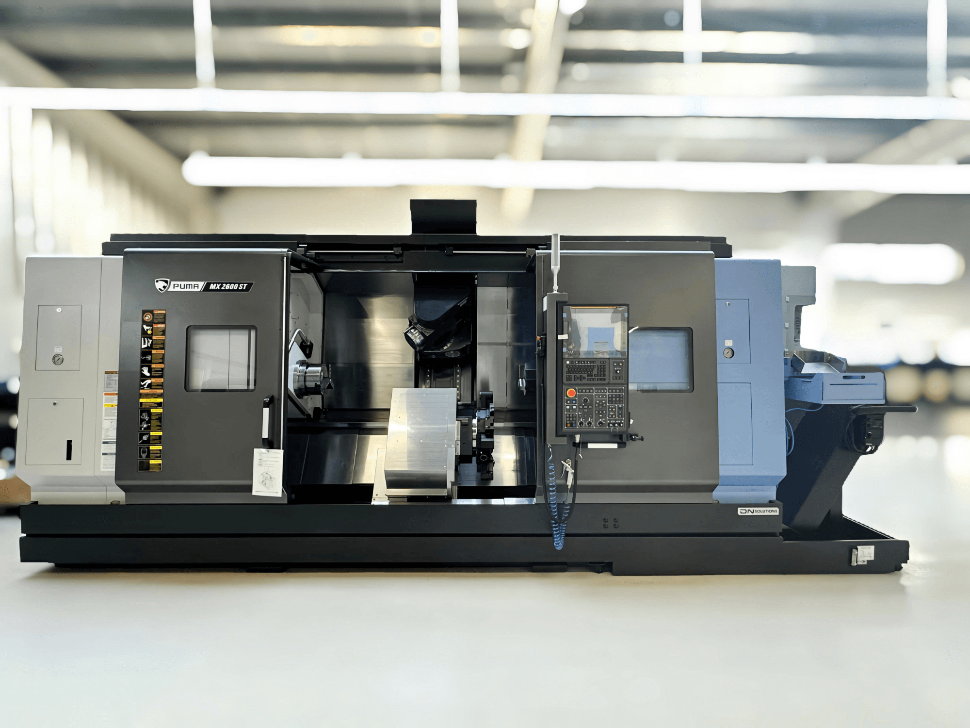 Puma MX2600ST draai-freescentrum in zijaanzicht, met gedetailleerd bedieningspaneel en bewerkingsgebied met zichtbare gereedschappen.