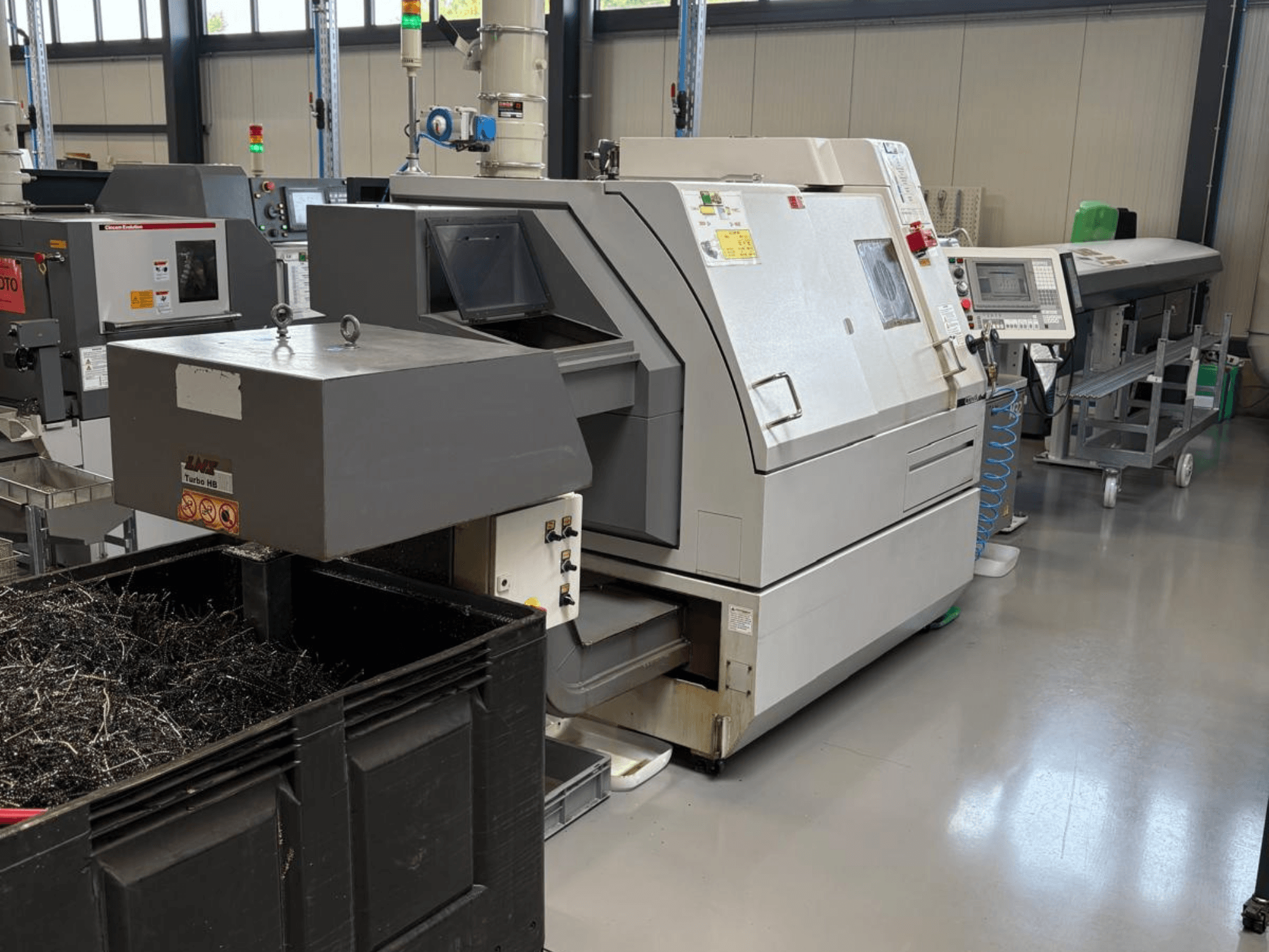 LTA Turbo H8 industriële machine, zijaanzicht, met een grote container voor metaalschilfers en bedieningspaneel in een fabrieksomgeving.