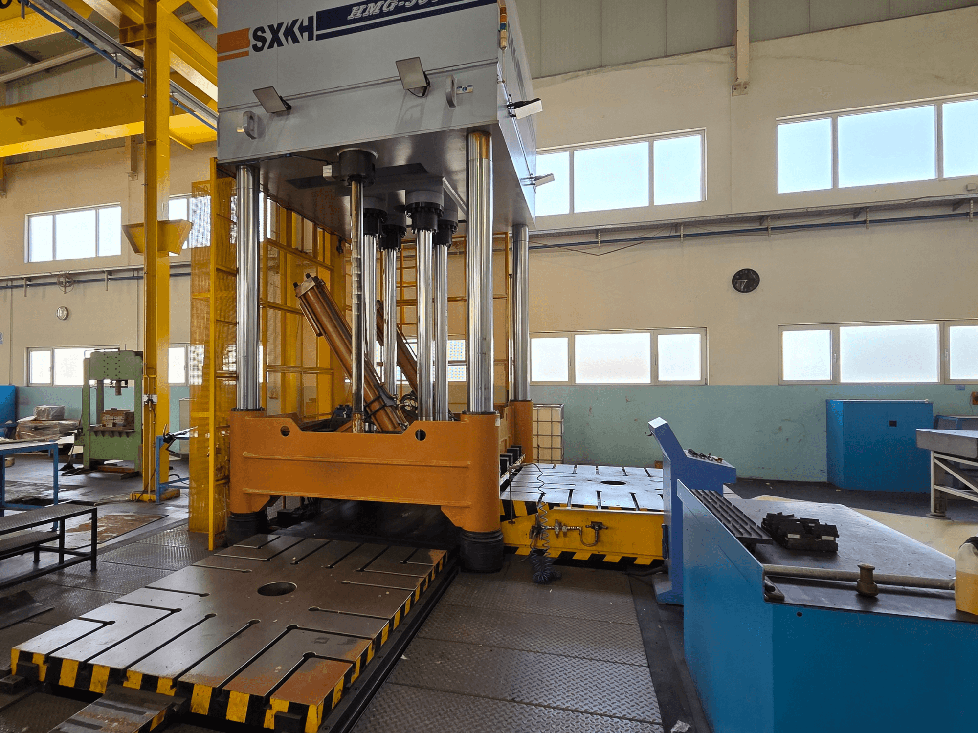 Hydraulische pers SXKH HMG-300JM vooraanzicht, met grote perscilinders en een robuuste basis in een fabrieksomgeving.