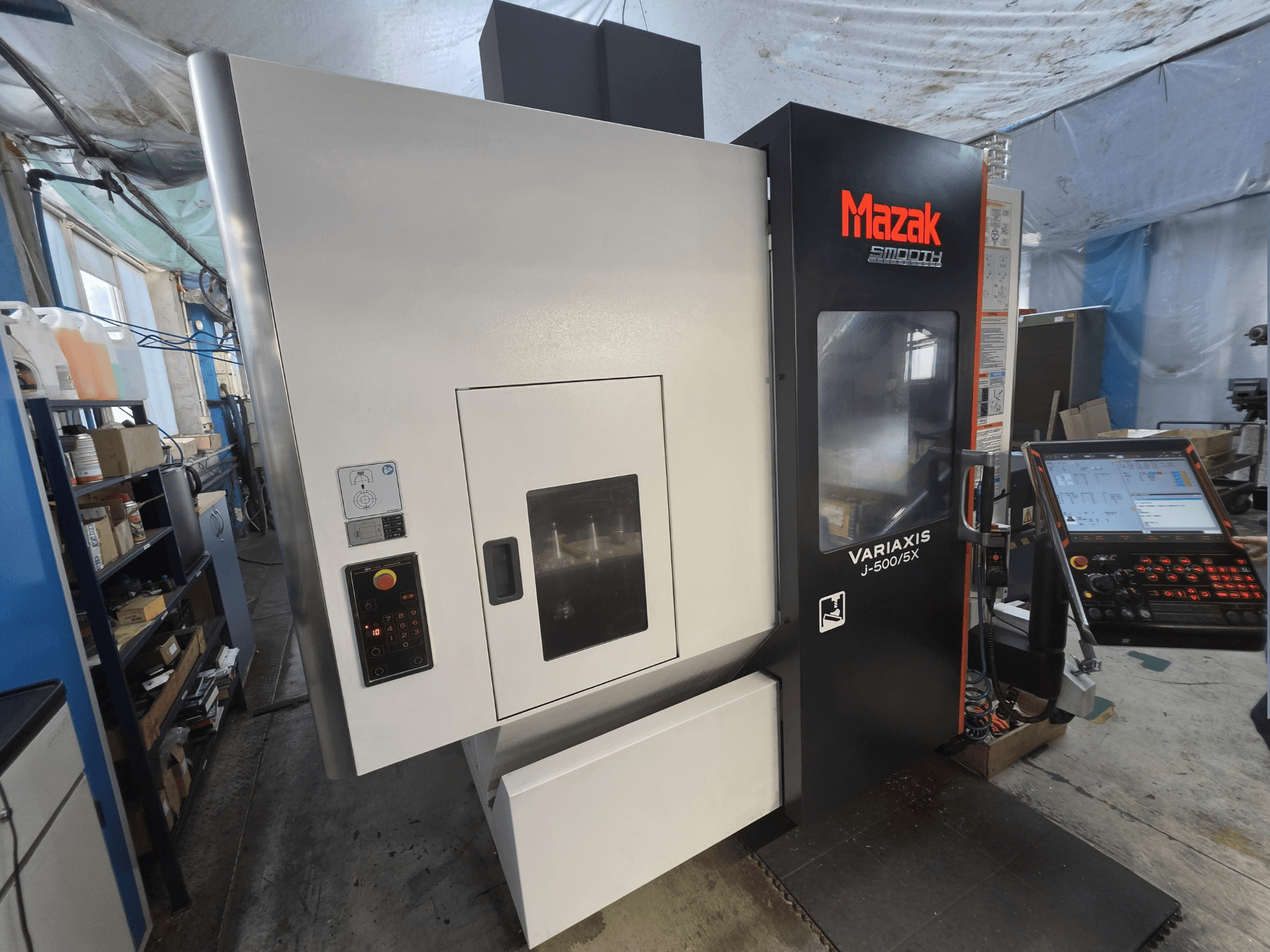 Verticaal bewerkingscentrum Mazak VARIAXIS J-500/5X in vooraanzicht, met een bedieningspaneel en een groot venster op de bewerkingsruimte.