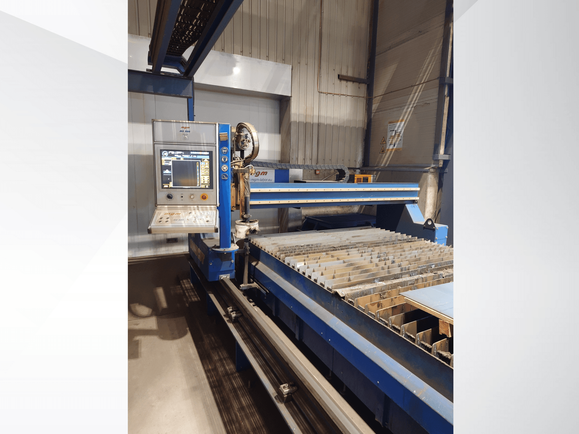 CNC snijmachine van PlasmaCam, vooraanzicht met bedieningspaneel en metalen snijbed met latten.