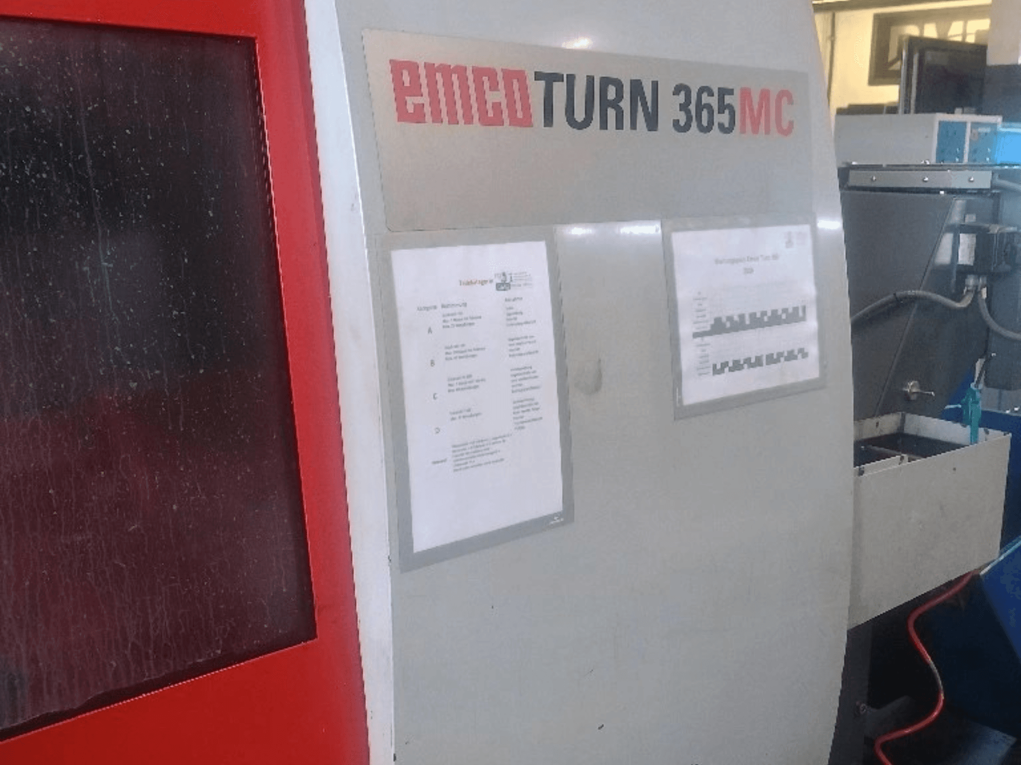 EMCO EmcoTurn 365 MC horizontale draaimachine, zijaanzicht met bedieningspaneel, handleidingen en blauwe koelvloeistoftank zichtbaar.