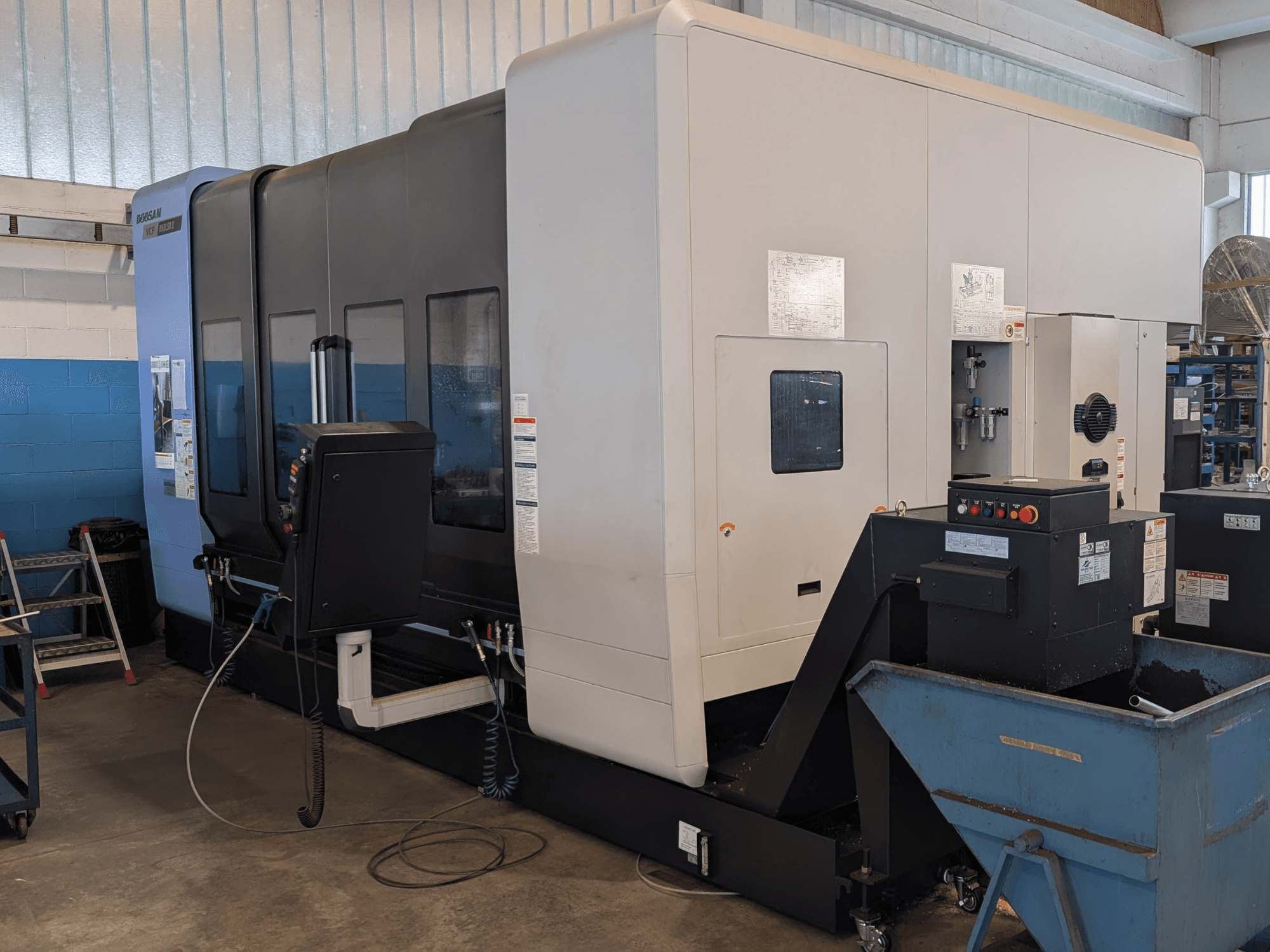 Verticaal bewerkingscentrum DOOSAN VCF850LSR-II in zijaanzicht, met het bedieningspaneel, het koelsysteem en de robuuste constructie.
