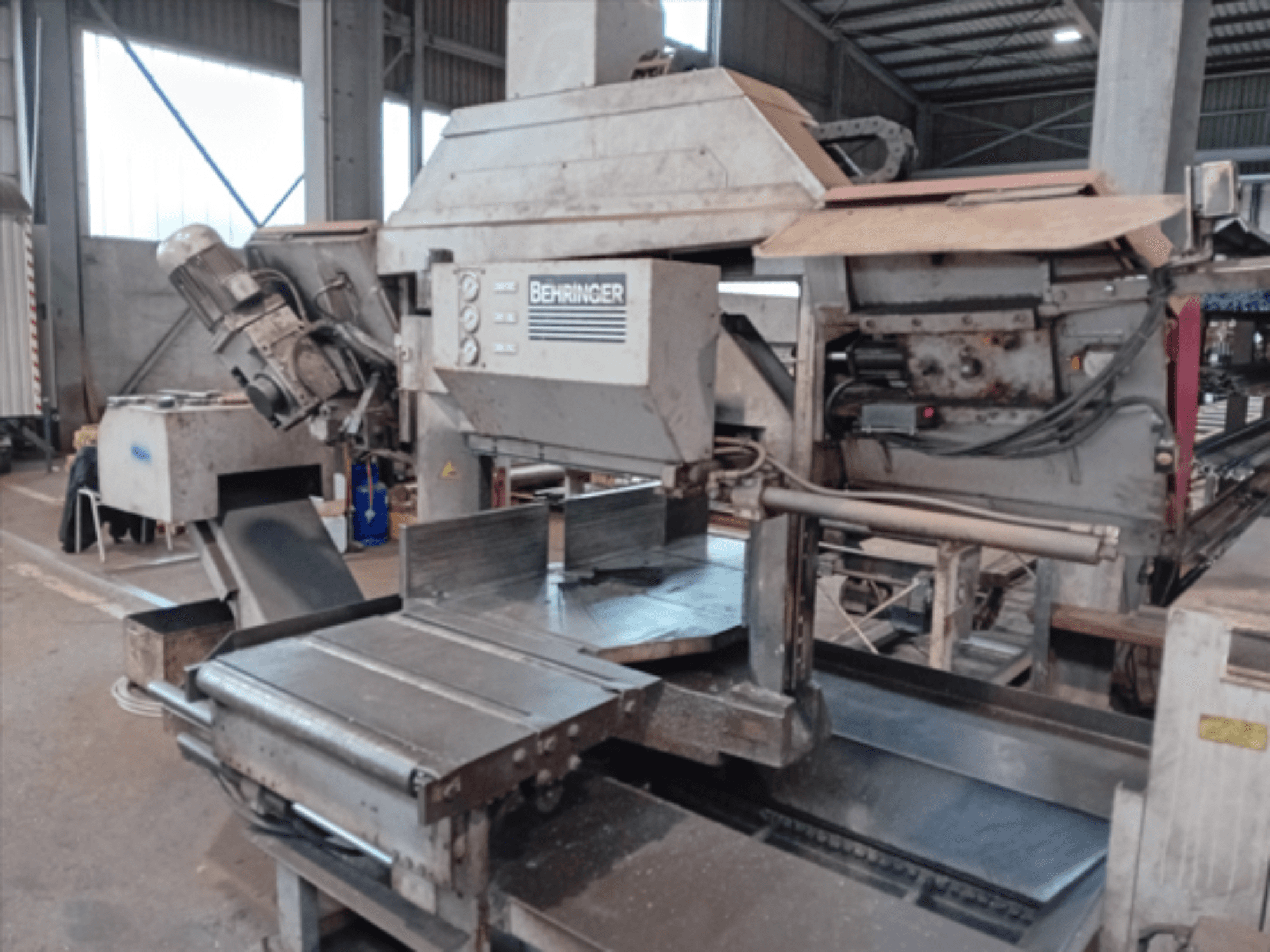 Behringer lintzaag, vooraanzicht, heeft een groot zaagblad, motor en verstelbare tafel, ideaal voor het zagen van metaal in een werkplaats.