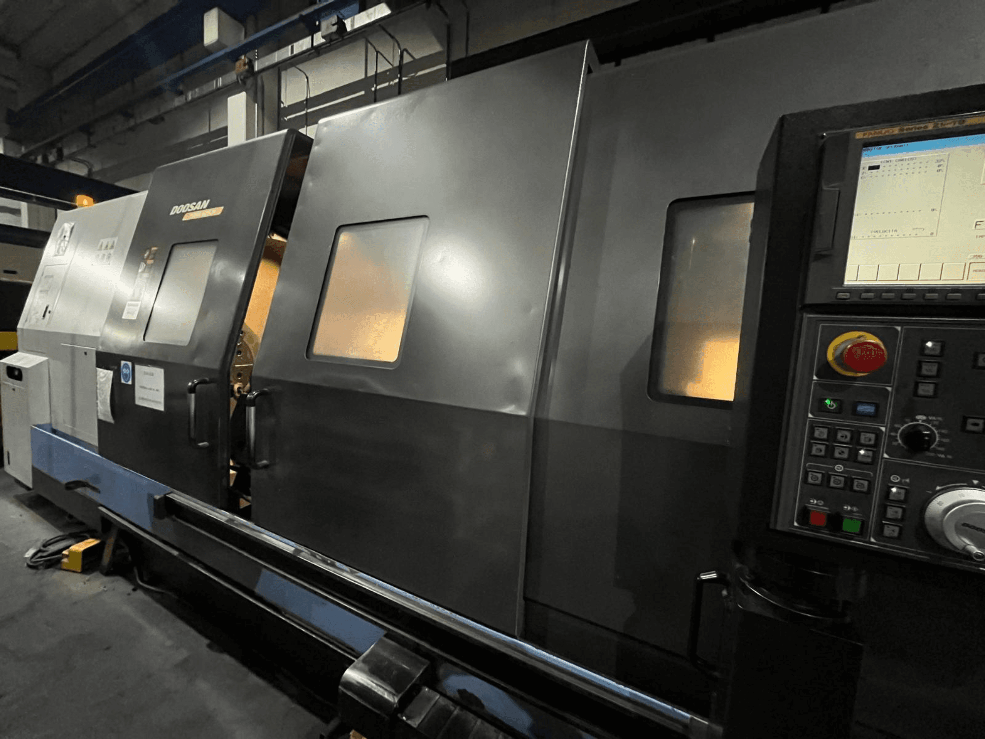 Doosan CNC draaibank in vooraanzicht, met bedieningspaneel en bedieningsinterface met zichtbaar digitaal display en knoppen.