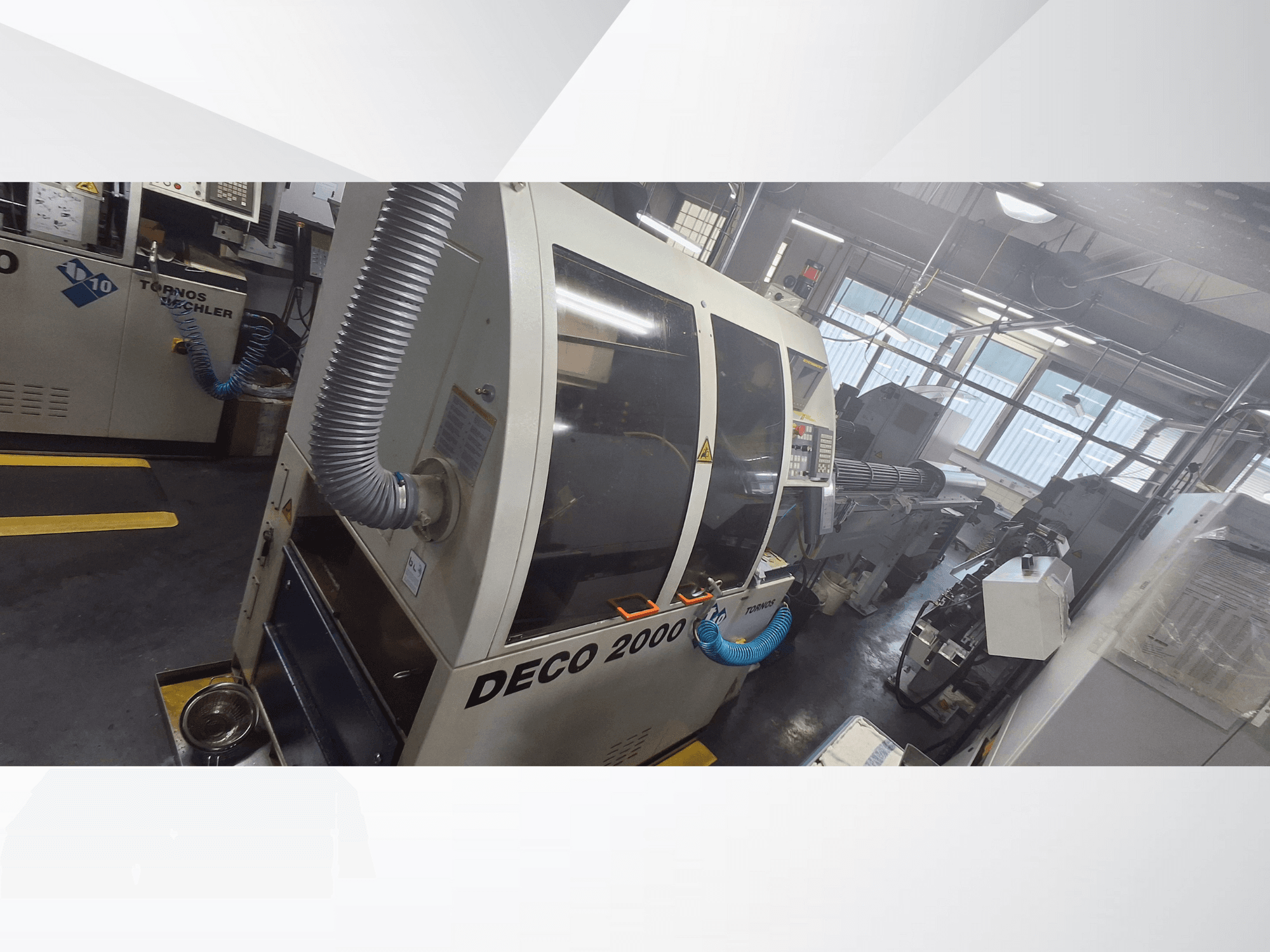 DECO 2000 CNC machine in werkplaats, vooraanzicht, met ventilatieslang en bedieningspaneel, ontworpen voor precisiebewerking.