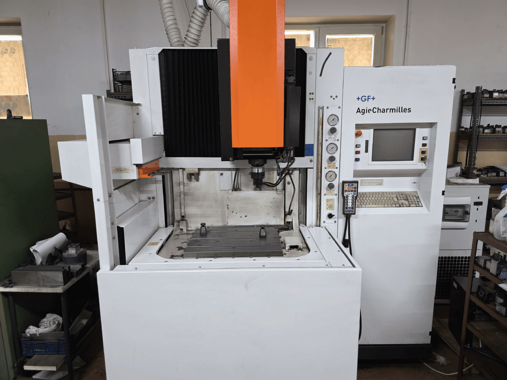 GF AgieCharmilles CNC machine, vooraanzicht met een opvallende oranje spindel, digitaal bedieningspaneel en gemonteerde boortafel.