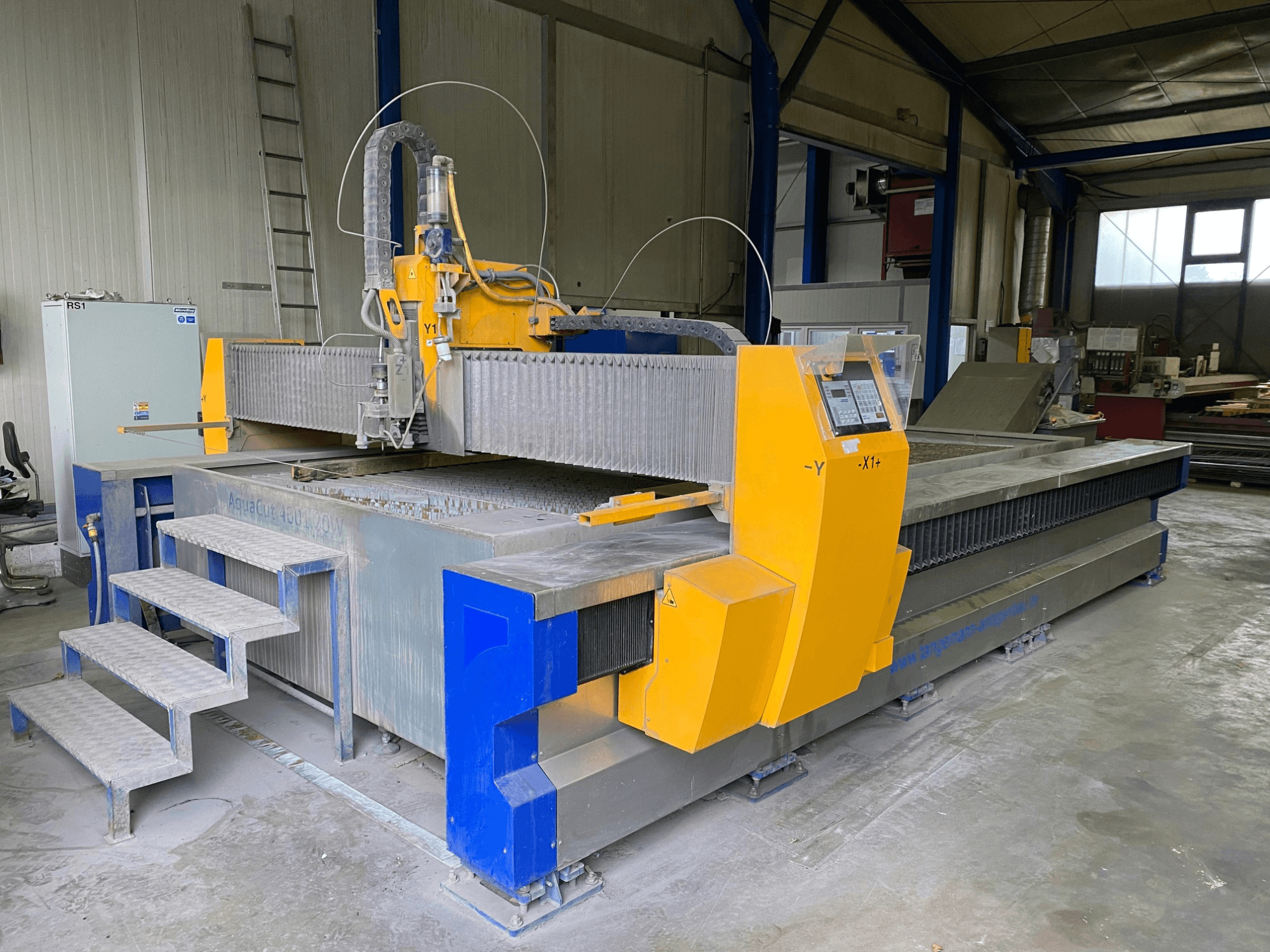 MicroStep AquaCut-W 4001.20 waterstraalsnijmachine in een werkplaats, met de stappen en het bedieningspaneel in zijaanzicht.