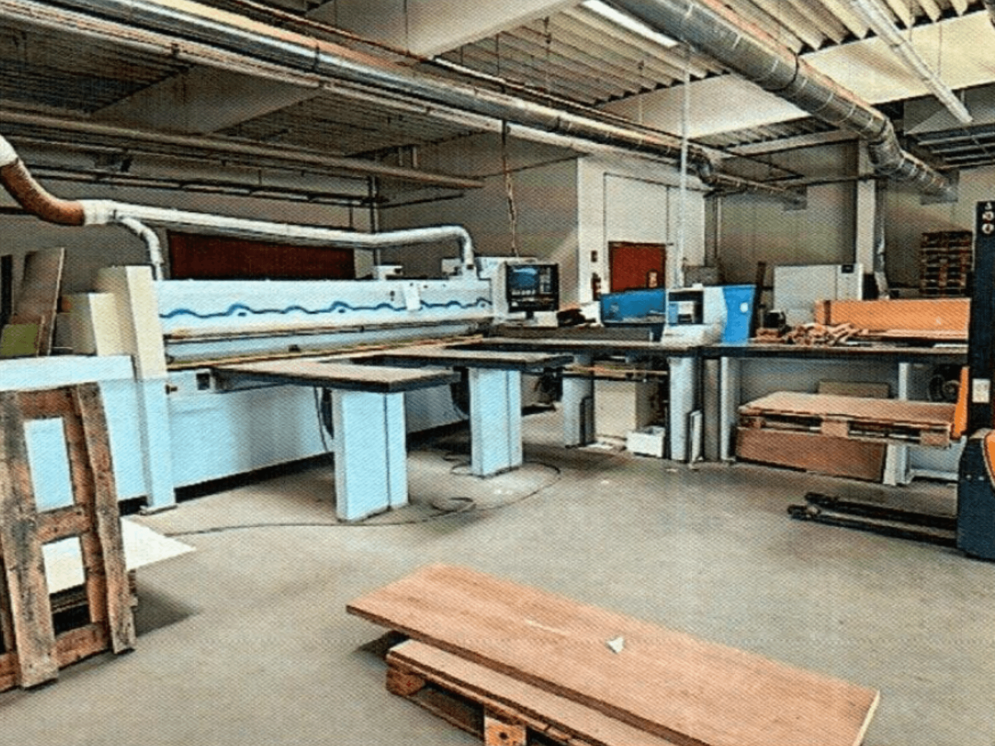 HOMAG HPL 11/38/22 paneelzaag in een werkplaats, met een grote zaagtafel en displayconsole, gezien vanaf de voorkant.