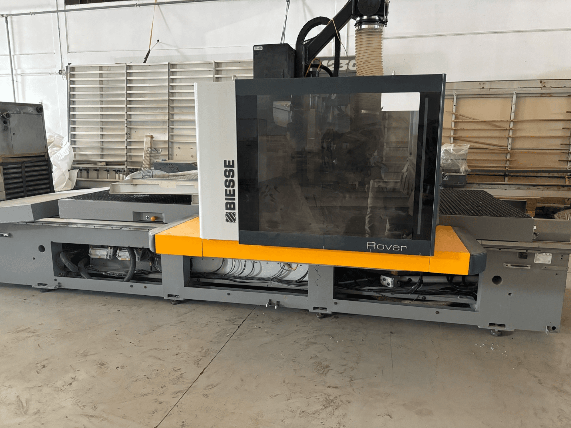 Biesse Rover CNC-bewerkingscentrum, vooraanzicht, met groot bedieningspaneel, gele accenten en zichtbare mechanische onderdelen.