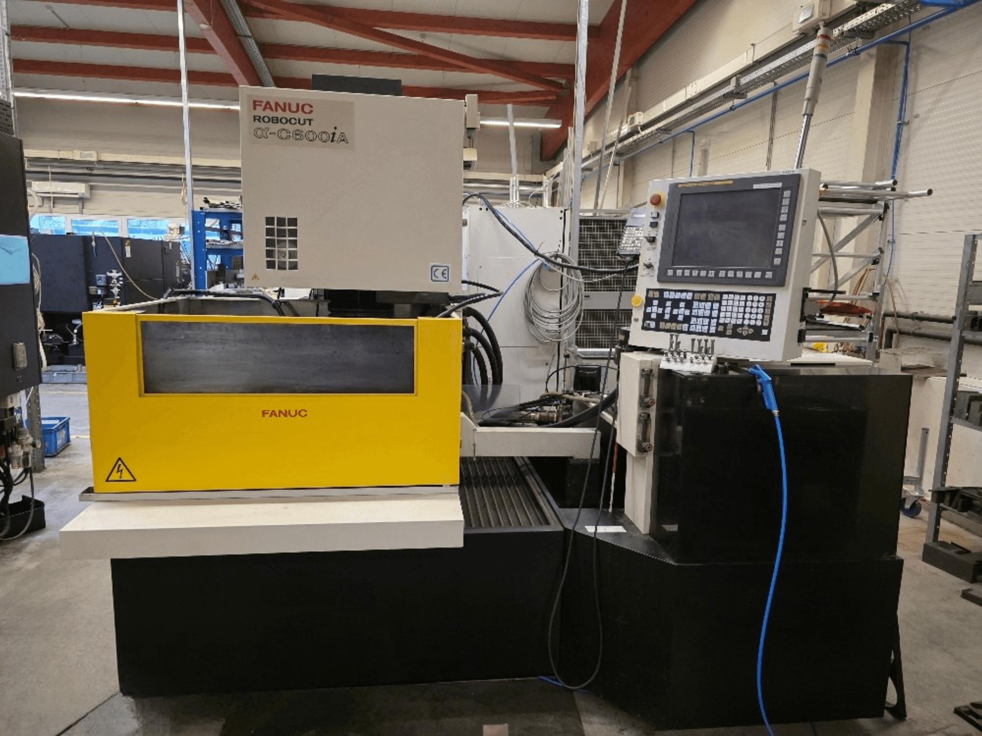 FANUC Robocut α-C600iA draadsnijmachine, vooraanzicht, met een geel bedieningspaneel en digitaal display.