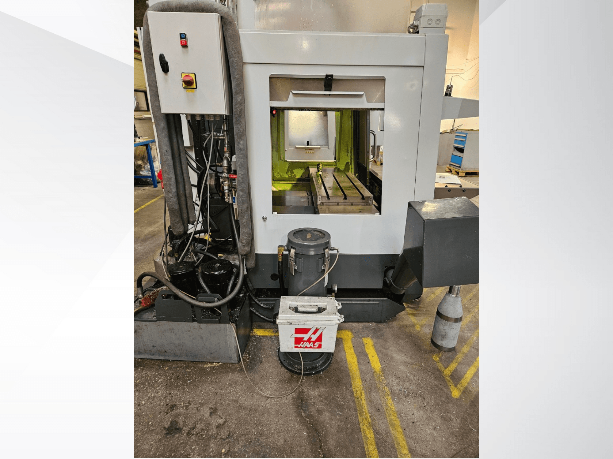 Het vooraanzicht van de Haas CNC machine toont het bedieningspaneel, de koelvloeistoftank en het bewerkte bed.