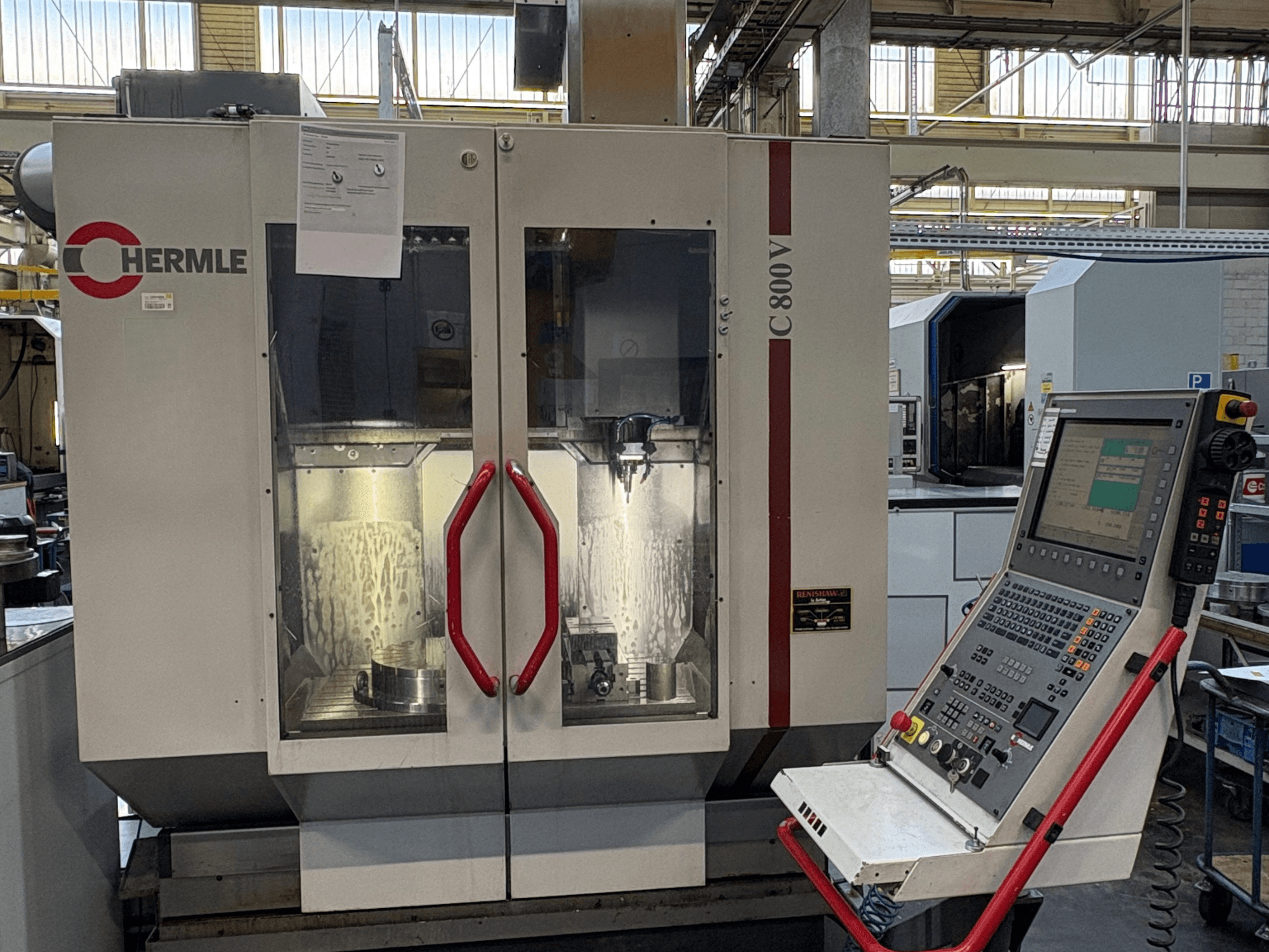 HERMLE C 800 V verticaal bewerkingscentrum, vooraanzicht, met deuren met rode handgrepen en bedieningspaneel aan de rechterkant.