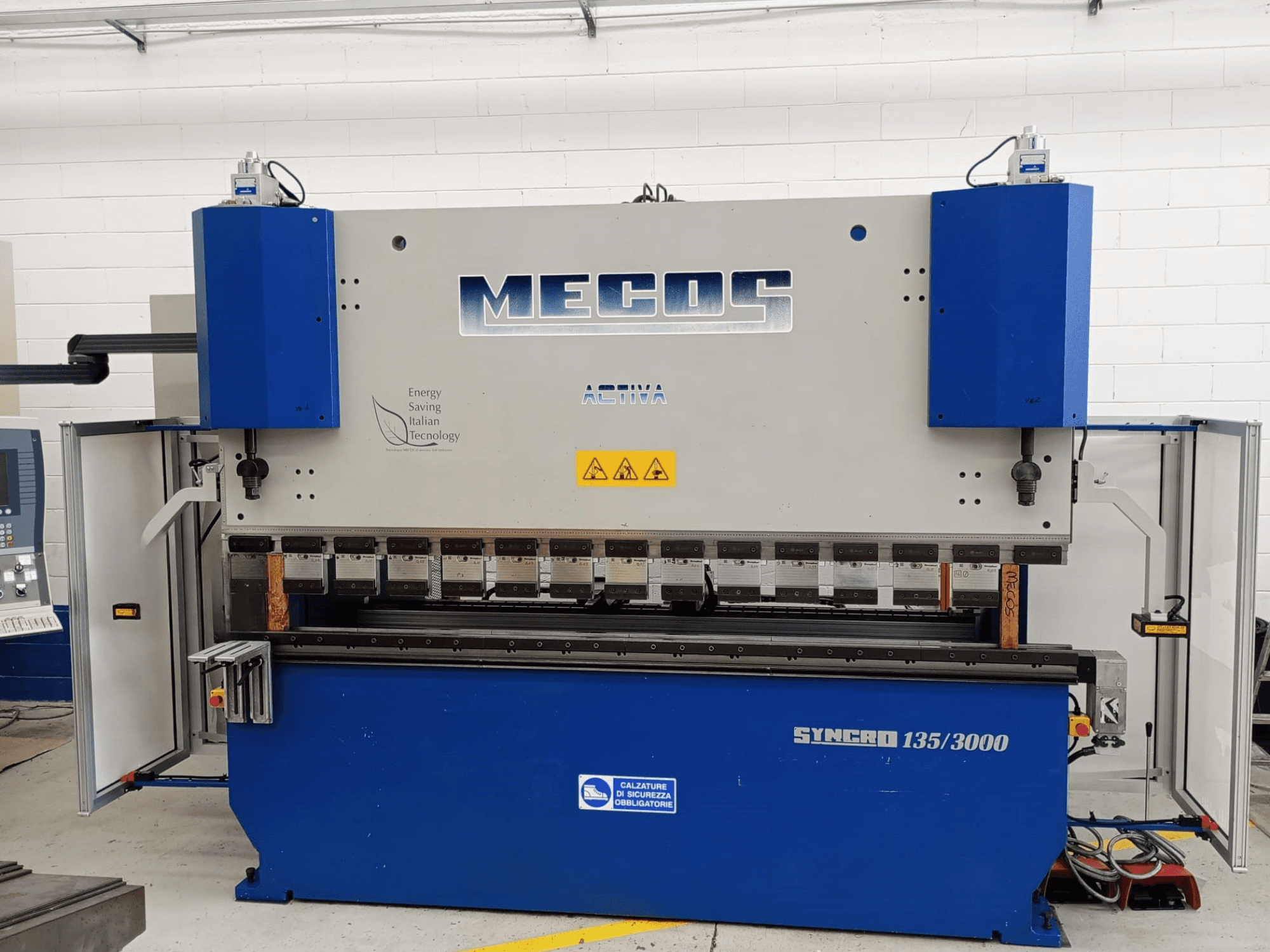 Het vooraanzicht van de MECOS SYNCRO 135/3000 afkantpers, met de bedieningselementen, buiggereedschappen en veiligheidsfuncties.