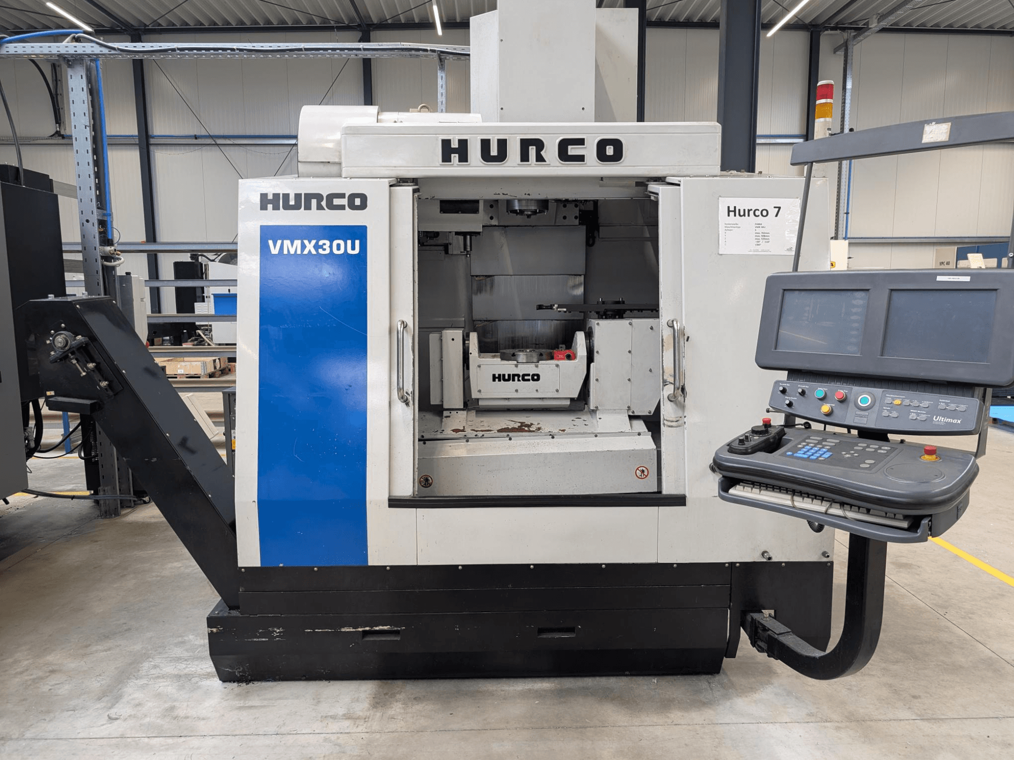 Hurco VMX30U CNC machine in vooraanzicht met bedieningspaneel; heeft een ruim interieur en precisie bedieningsinterface.