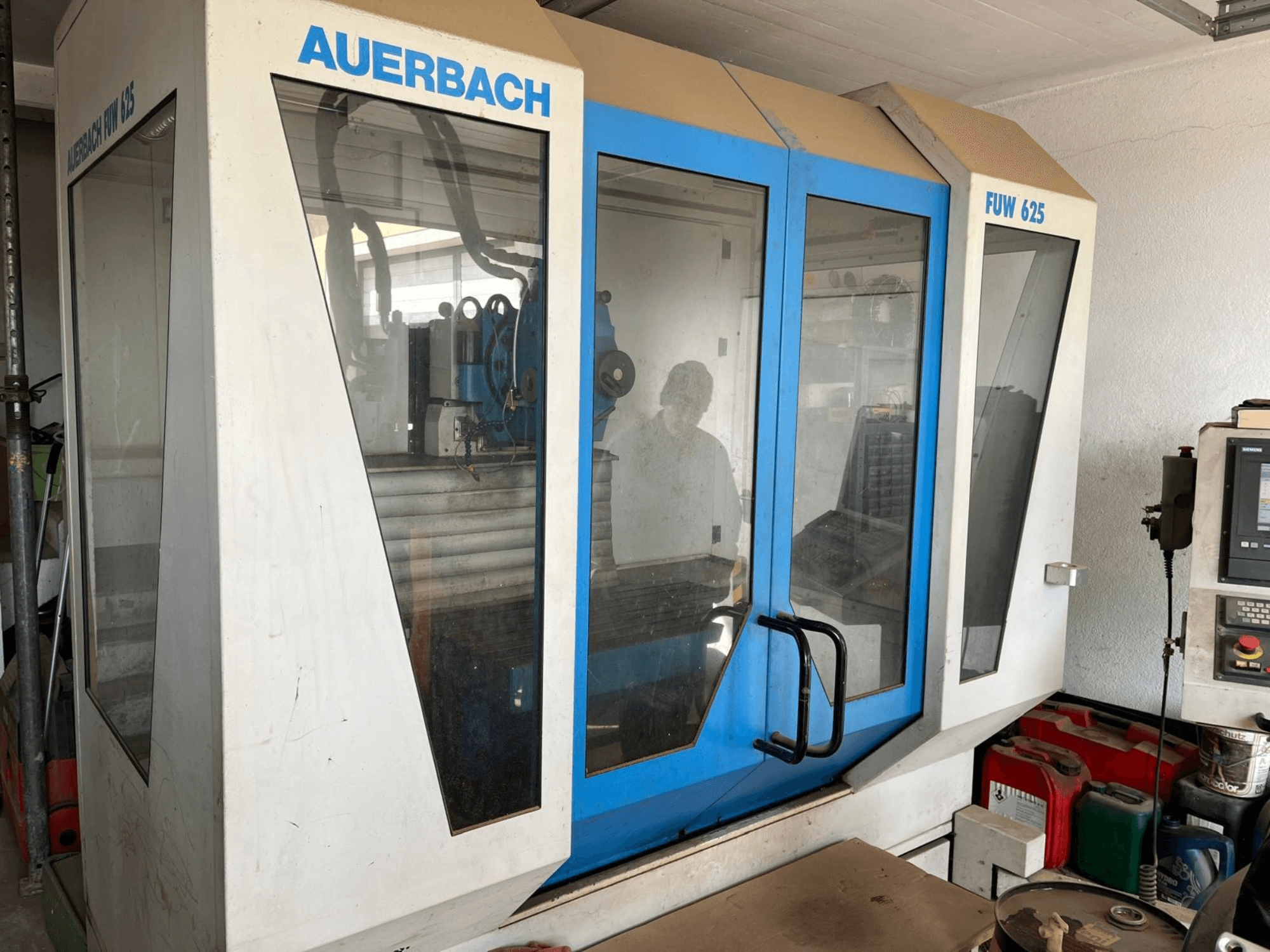 Auerbach FUW 625 Universeel Bewerkingscentrum in zijaanzicht, met glazen panelen en een bedieningspaneel rechts.