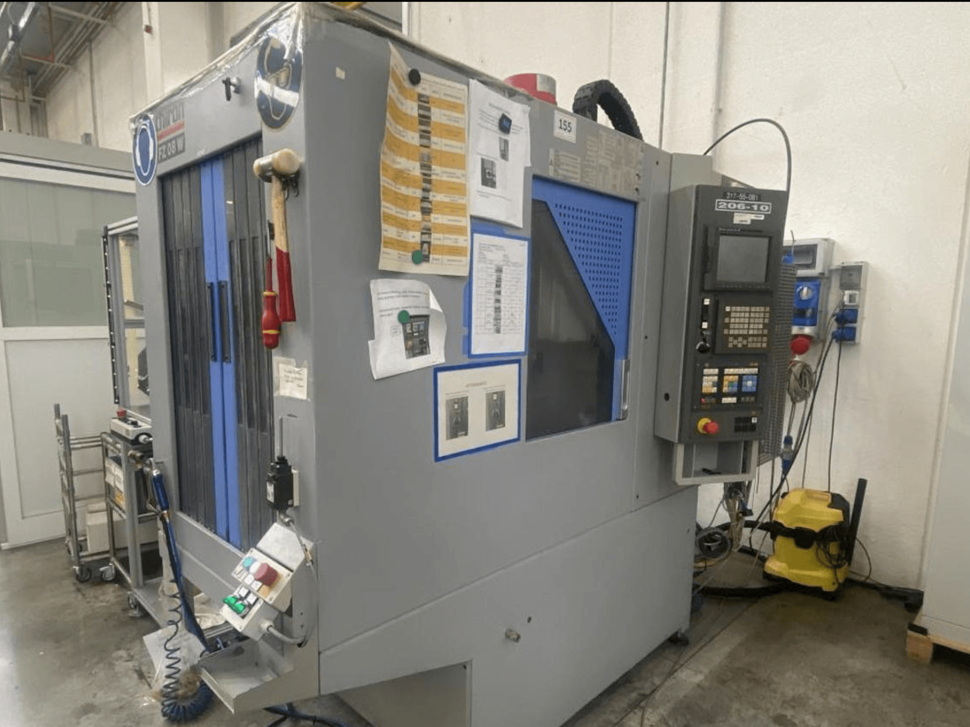 CNC machine van Shin Lin, vooraanzicht, met bedieningspaneel, bedieningsknoppen en bijgevoegde veiligheidsinstructies.