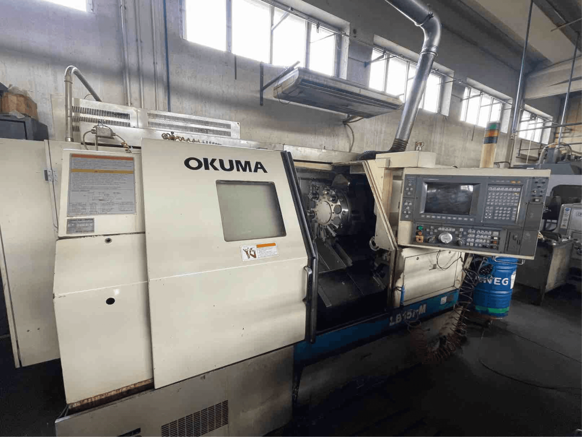 Okuma LB15i-M horizontale draaimachine, vooraanzicht; voorzien van bedieningspaneel en snijgereedschapgedeelte met gedetailleerde indicatoren.