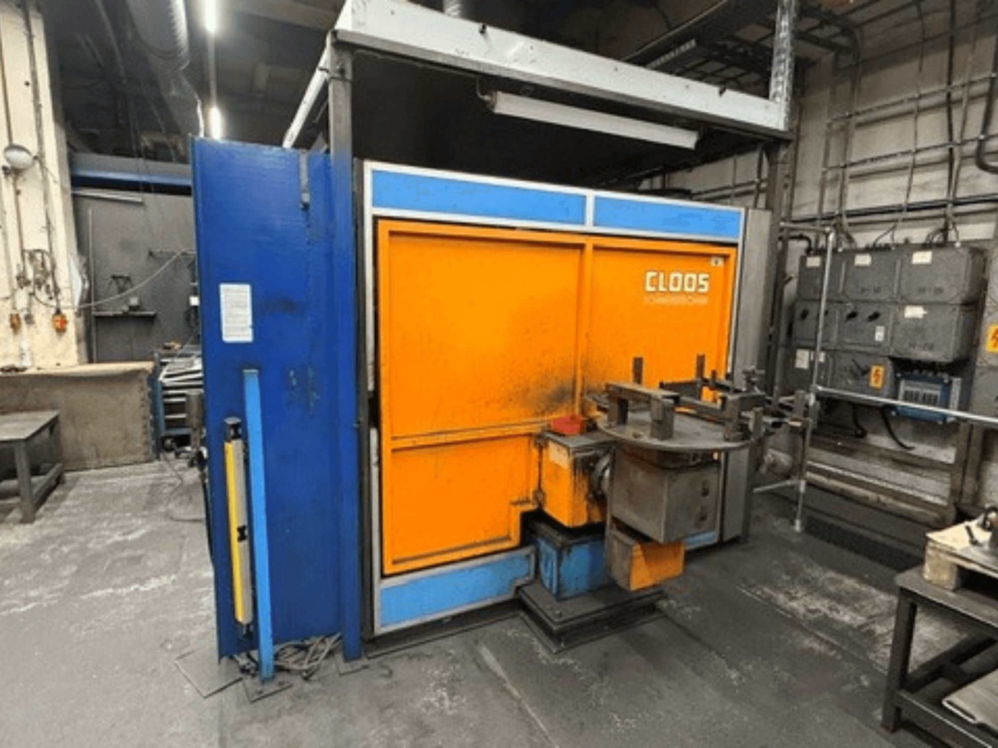 CLOOS Romat 320-lasrobot in een werkplaats, vooraanzicht met oranje en blauwe behuizing, bedieningspaneel en gereedschap.