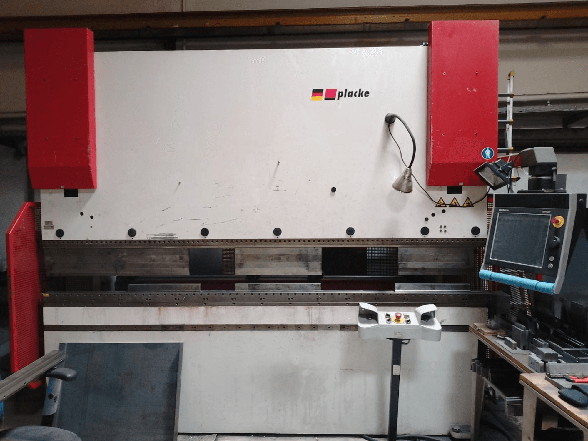 Kantpers PLACKE QPB-4 150/3100, vooraanzicht met bedieningspaneel, rode armen en het metalen buiggebied.