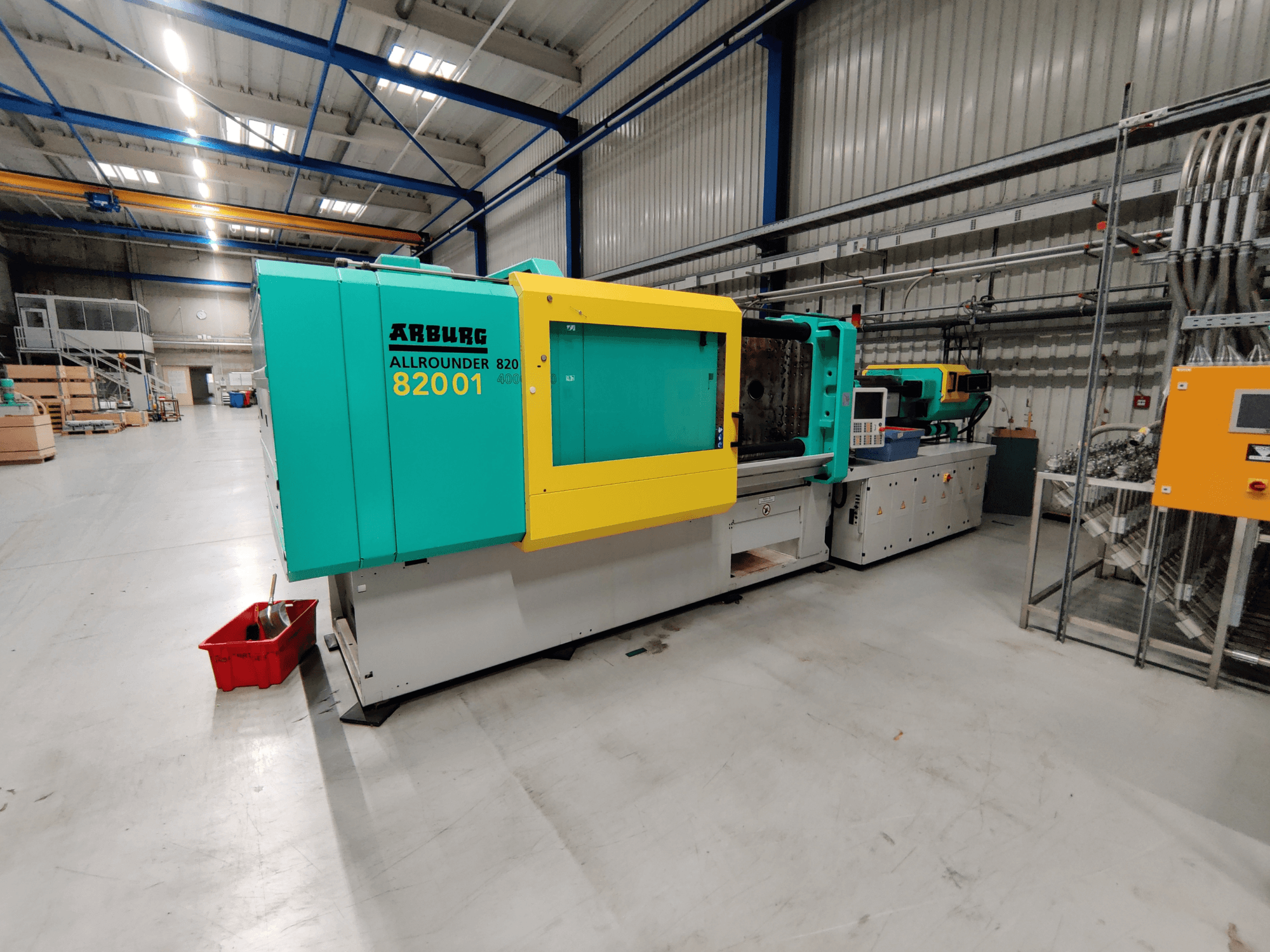 Vooraanzicht van een Arburg 820 S 4000-2100 hydraulische spuitgietmachine, met felgroene en gele panelen.